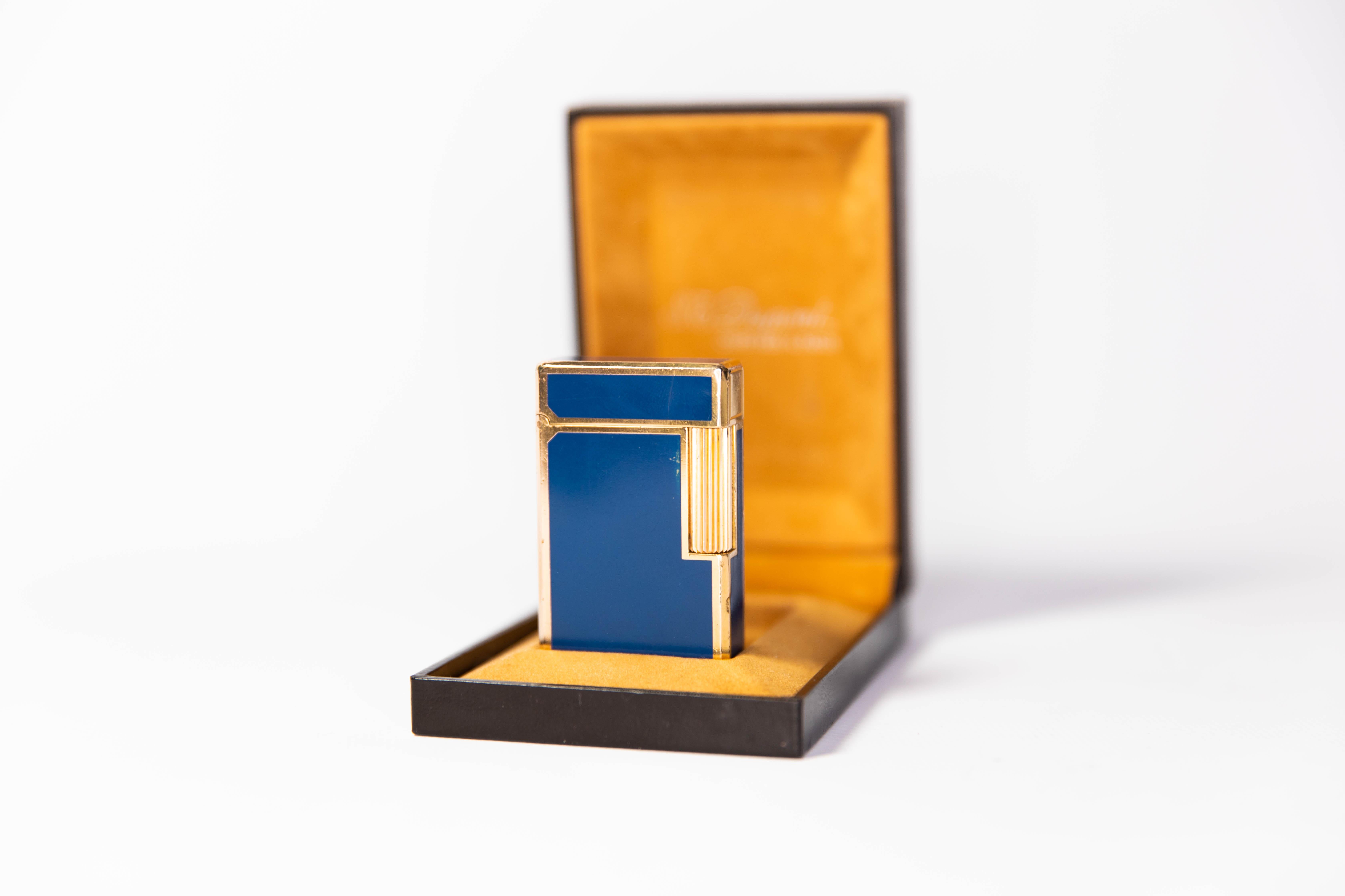 Vintage Gold Plated Ligne 1 BR ST Dupont Lighter Blue Laque de Chine 1980s In Box

The iconic S.T. Dupont name is known for quality, well-made cigarette lighters and other luxury implements. The company’s origin can be traced to Simon Tissot-Dupont