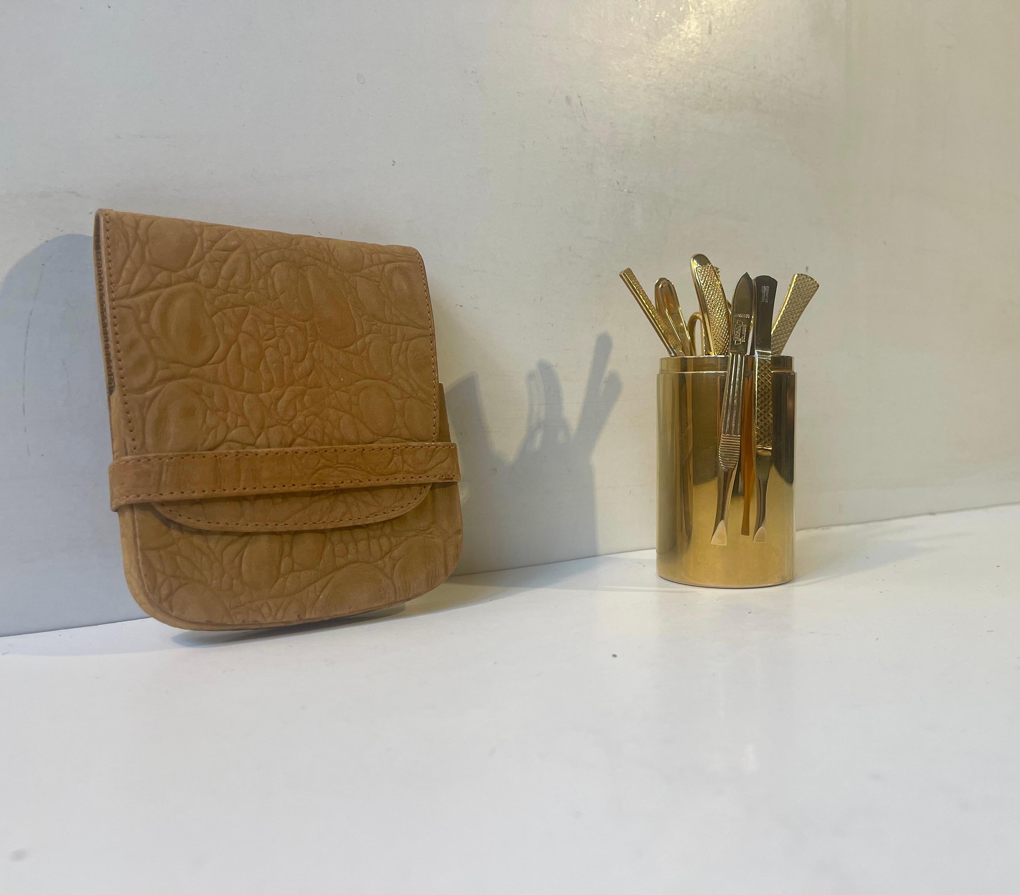 Decorative yet very useable vanity or travel manicure set consisting of 10 parts including the leather pouch and Gold Plated Cup. The manicure set was made by Gosol in Germany circa 1960-75 and the accompaning jar by Hugo Asmussen in Denmark. All