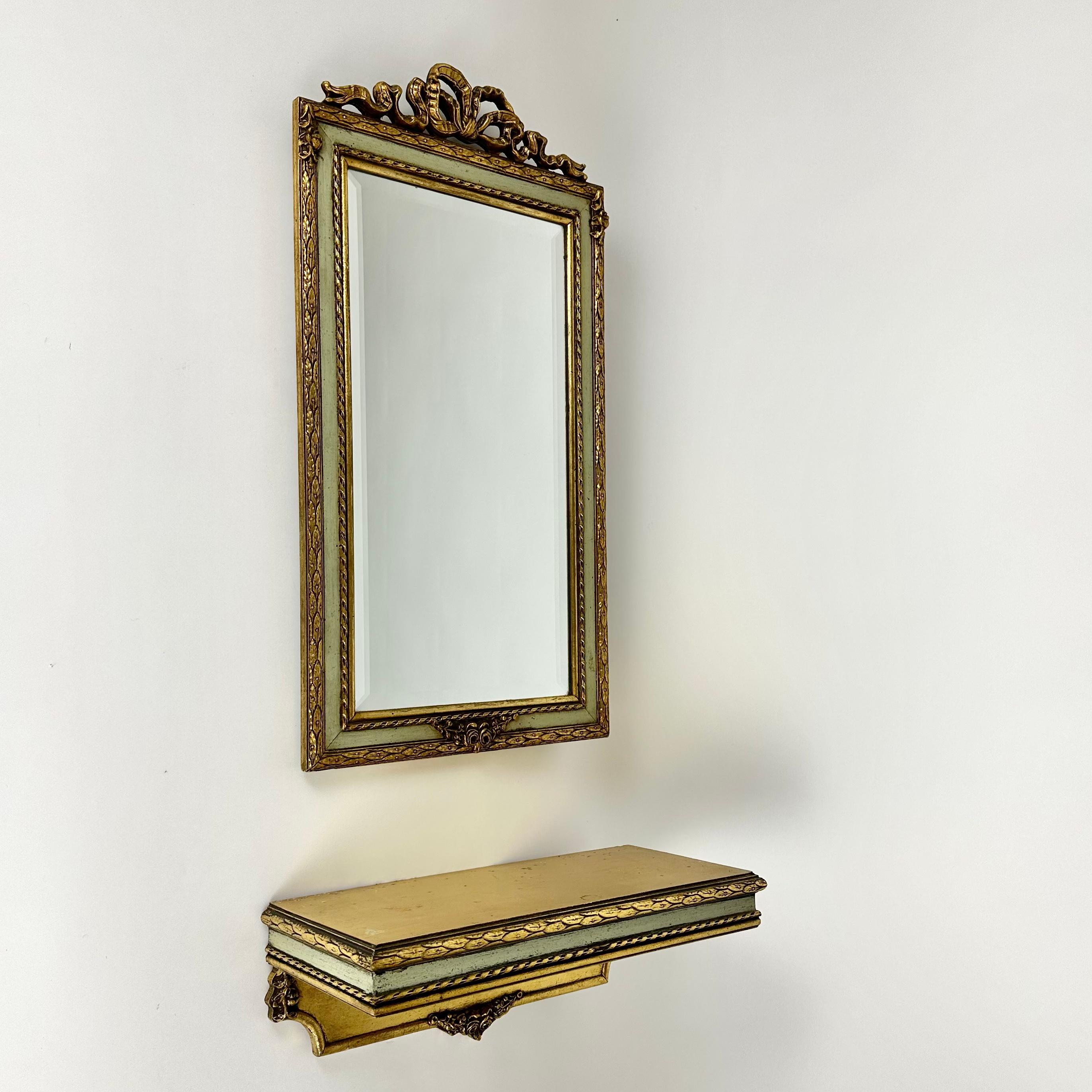 Very beautiful wall mirror in wooden carved frame with gold plated wooden console, Belgium, 1960s.

Hand-carved gilt wooden frame with floral decoration and a ribbon thread on the top centre.

This vintage set has been expertly crafted.

Our