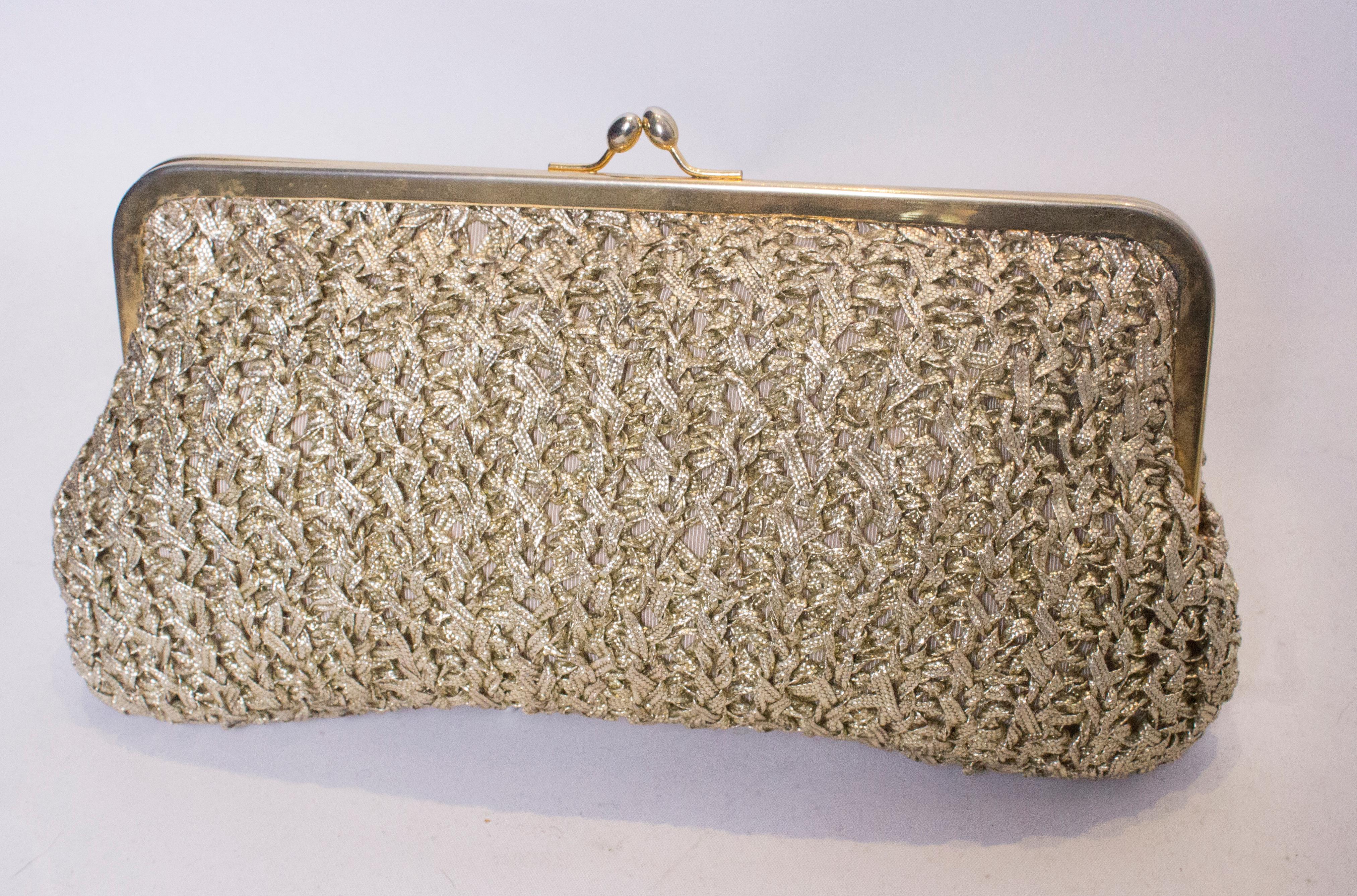 A chic gold raffia handbag with chain handle. The handle can be tucked inside and the bag used as a clutch bag as well as a handbag. The bag is fully lined.