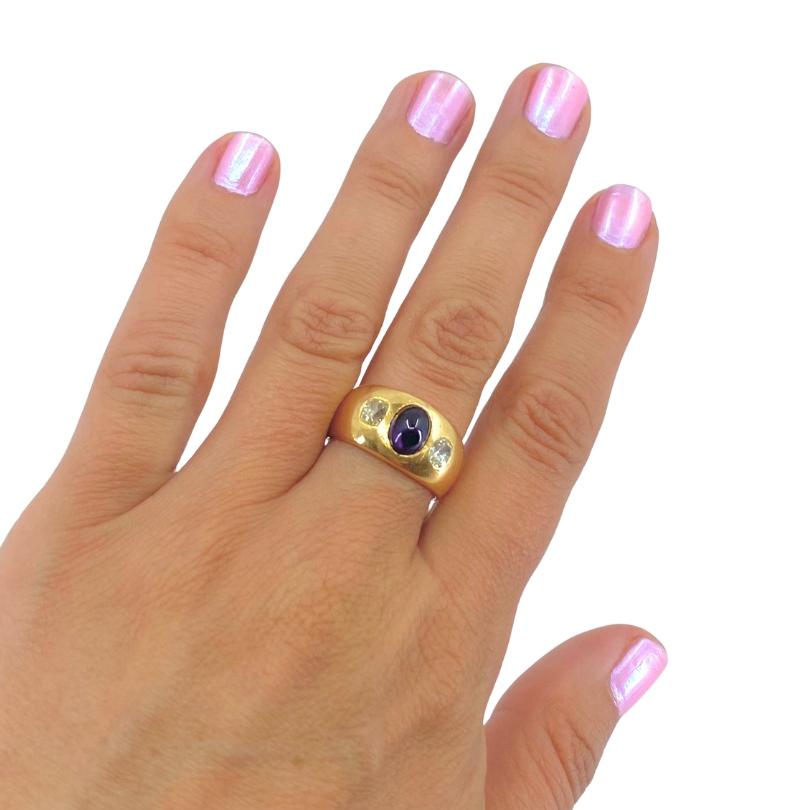 Anello vintage in oro 18k con tre pietre, diamanti e zaffiro.
Si tratta di un anello a forma di cupola con uno zaffiro cabochon blu intenso come centro,
affiancato da due diamanti. Le gemme sono incastonate a filo orizzontale, in modo che le pietre