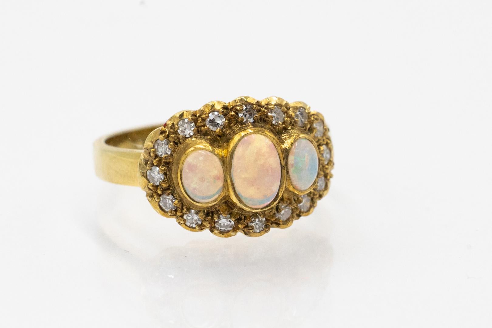 Vintage gold ring with opals and diamonds.

A delicate ring made of 14-karat yellow gold (0.585 fineness). Vintage ring decorated with 3 cabochon-cut opals, surrounded by diamonds with a total weight of approx. 0.32 ct.

Weight: 3.9 g,

Size: 15