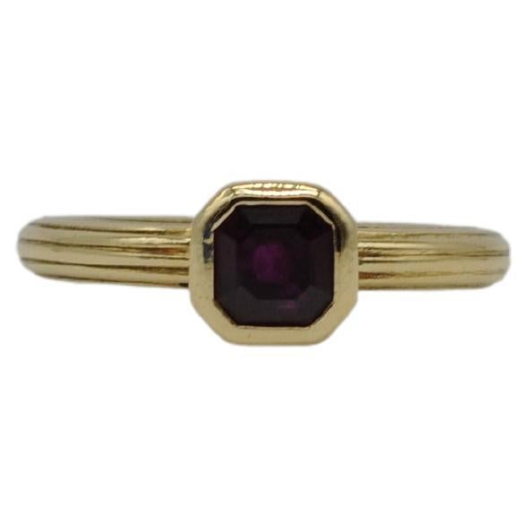 Immerse yourself in the captivating allure of this exquisite 18k yellow gold ring, a true statement of charm, beauty, and elegance. The centerpiece of this ring is an opulent, clear ruby that commands attention with its rich color and vivid