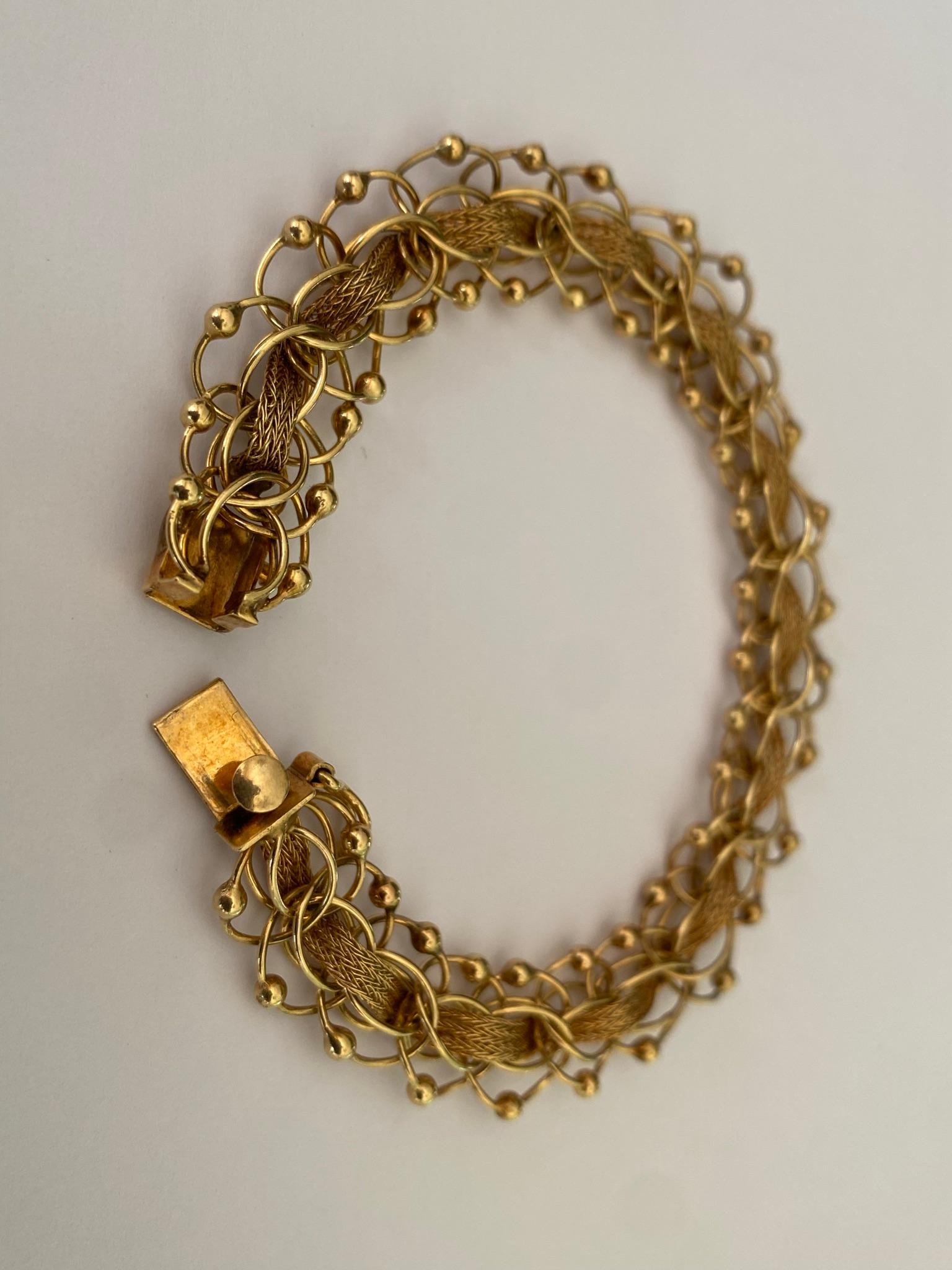 Crafted in the 1950s, this vintage link bracelet features a gold rope and delicate mesh design fashioned in 14kt yellow gold. The bracelet measures 7 inches. 
