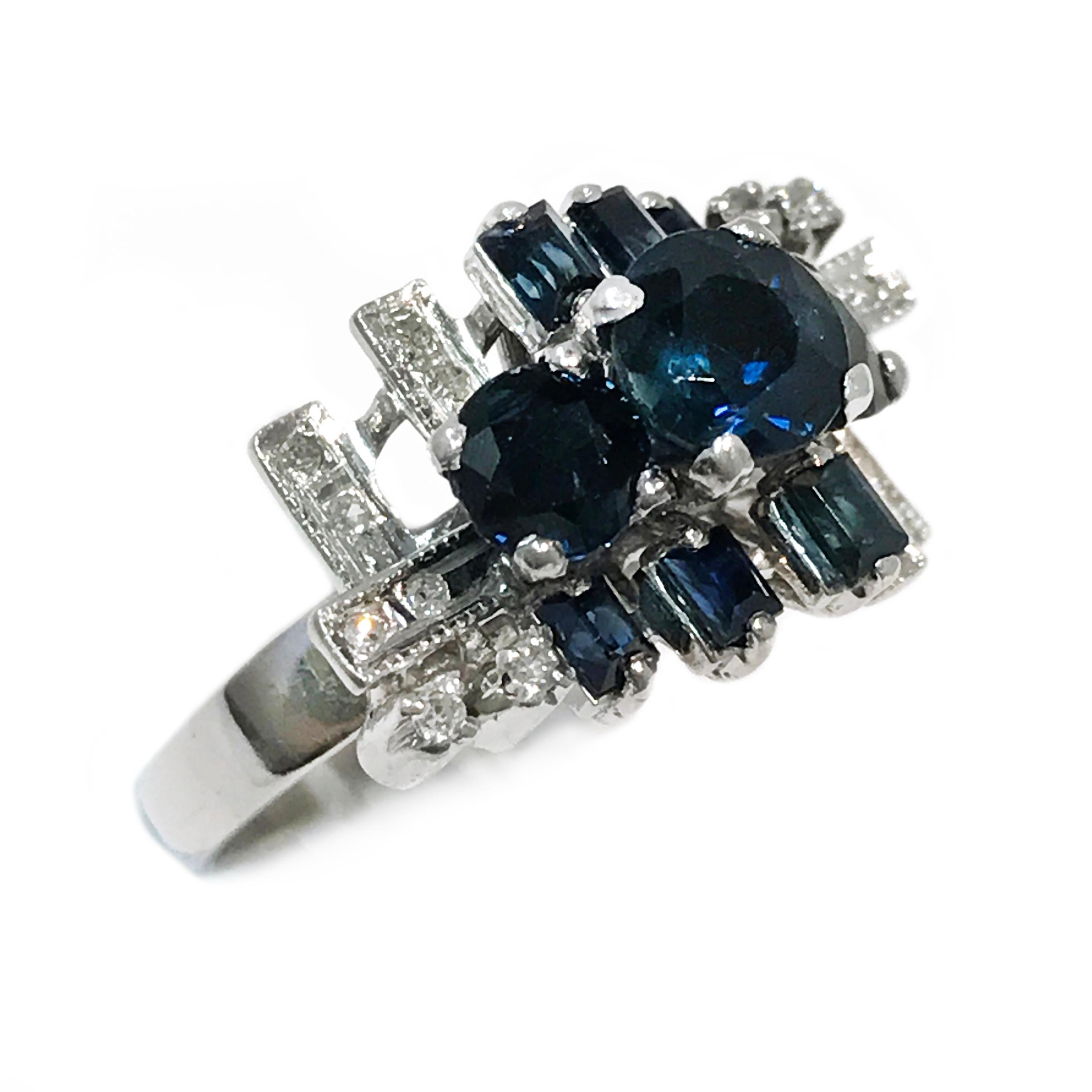 Vintage 18 karat white gold blue sapphire and diamond statement ring. The center round sapphire measures 5.77mm for a carat weight of 0.70ct. Two smaller round sapphires measure 4.64mm and six baguette sapphires for a total carat weight of 0.80tcw.