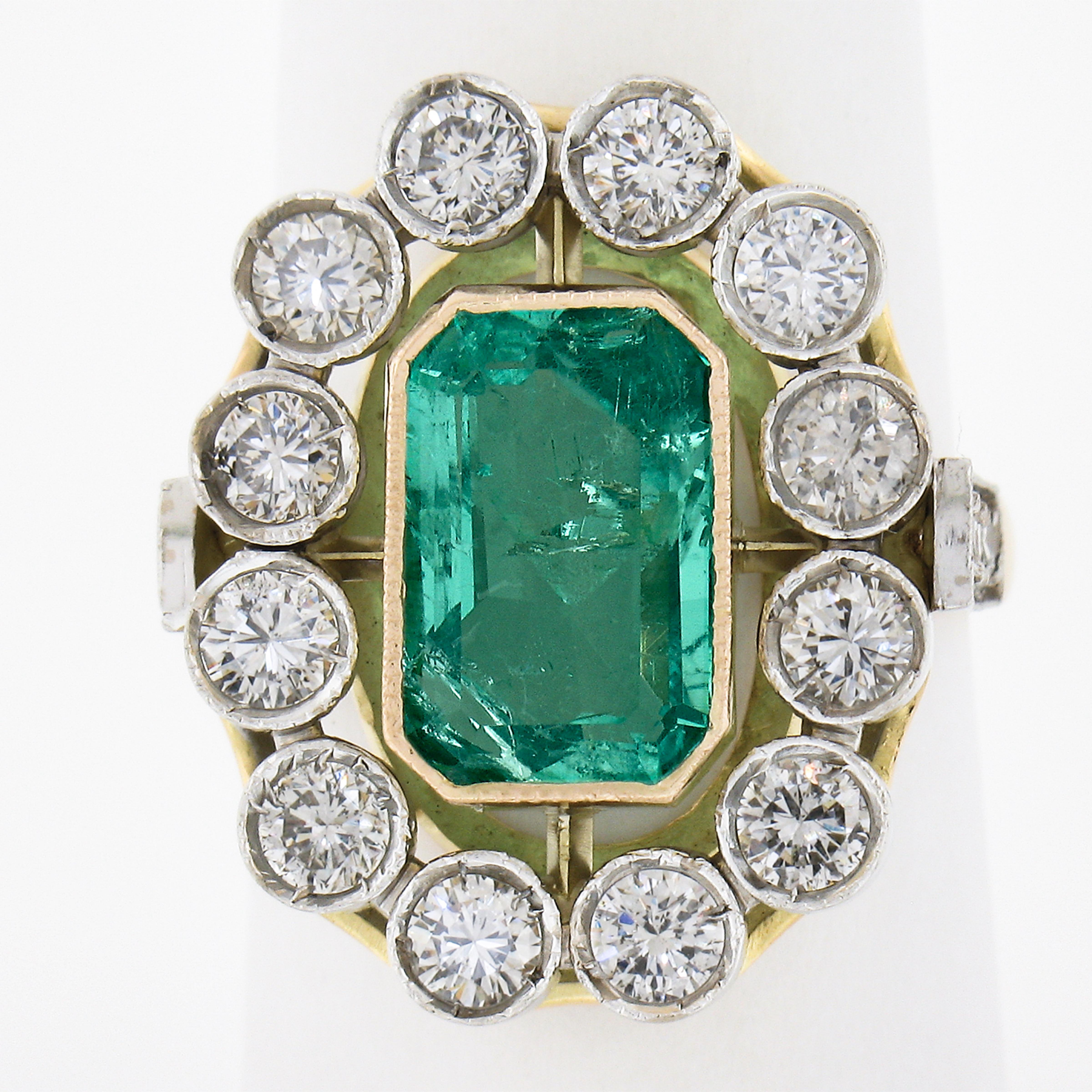 This magnificent emerald and diamond vintage cocktail ring features a GIA certified natural emerald with a nice elongated cut. This Colombian emerald displays light to medium green color and weighs approximately 2.60 carats. The nice large diamonds