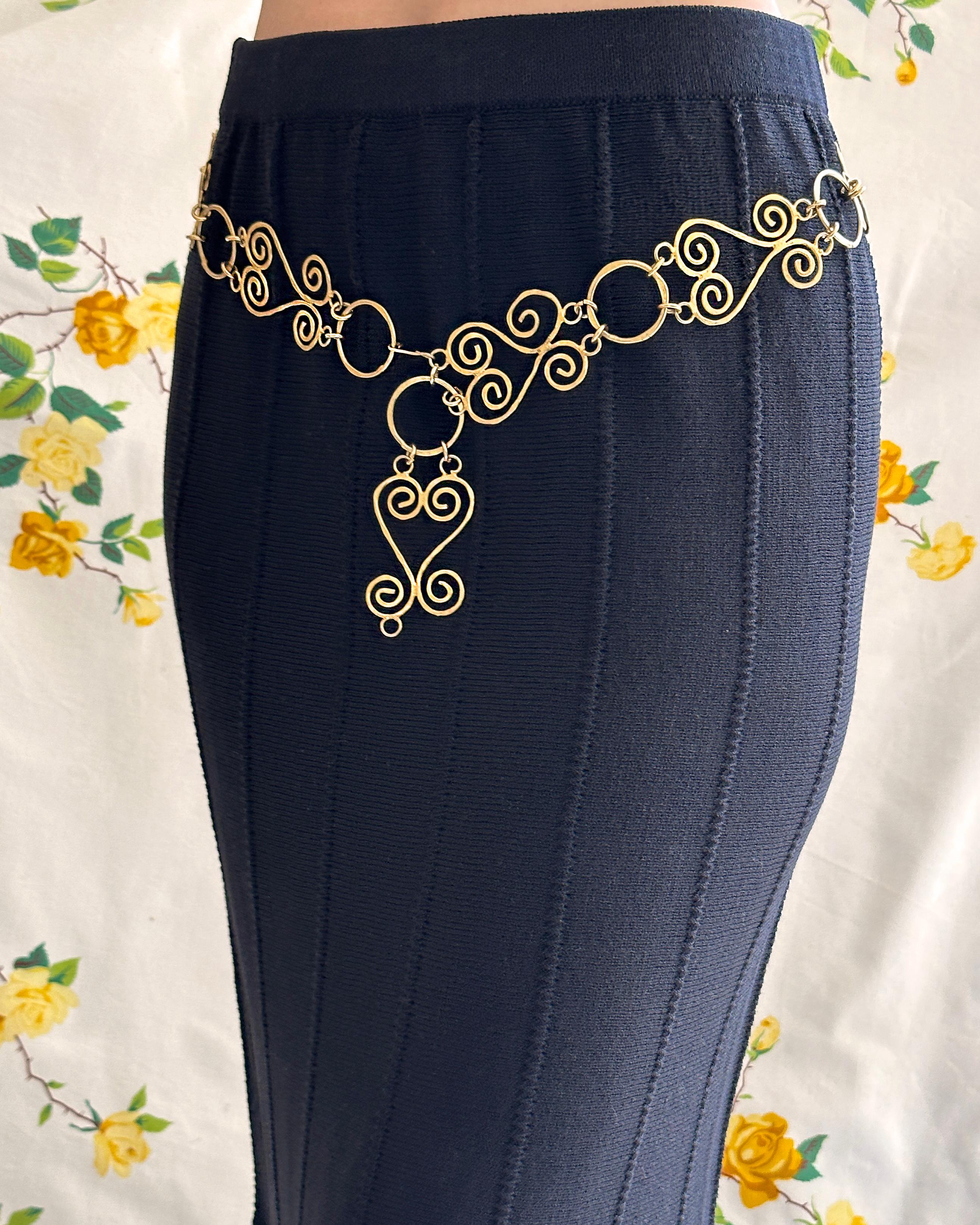 VERY BREEZY presents: This vintage chain belt feels straight off a 90s Chanel runway; it's really unlike any other I've seen. It features a sculptural swirling motif in a hammered matte gold. The hook clasp can connect to any link, which means this