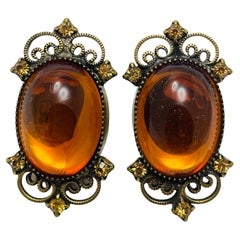 Boucles d'oreilles à clip vintage avec pierres en verre ambré et tonalités dorées.