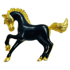 Broche vintage en émail noir doré représentant un cheval.