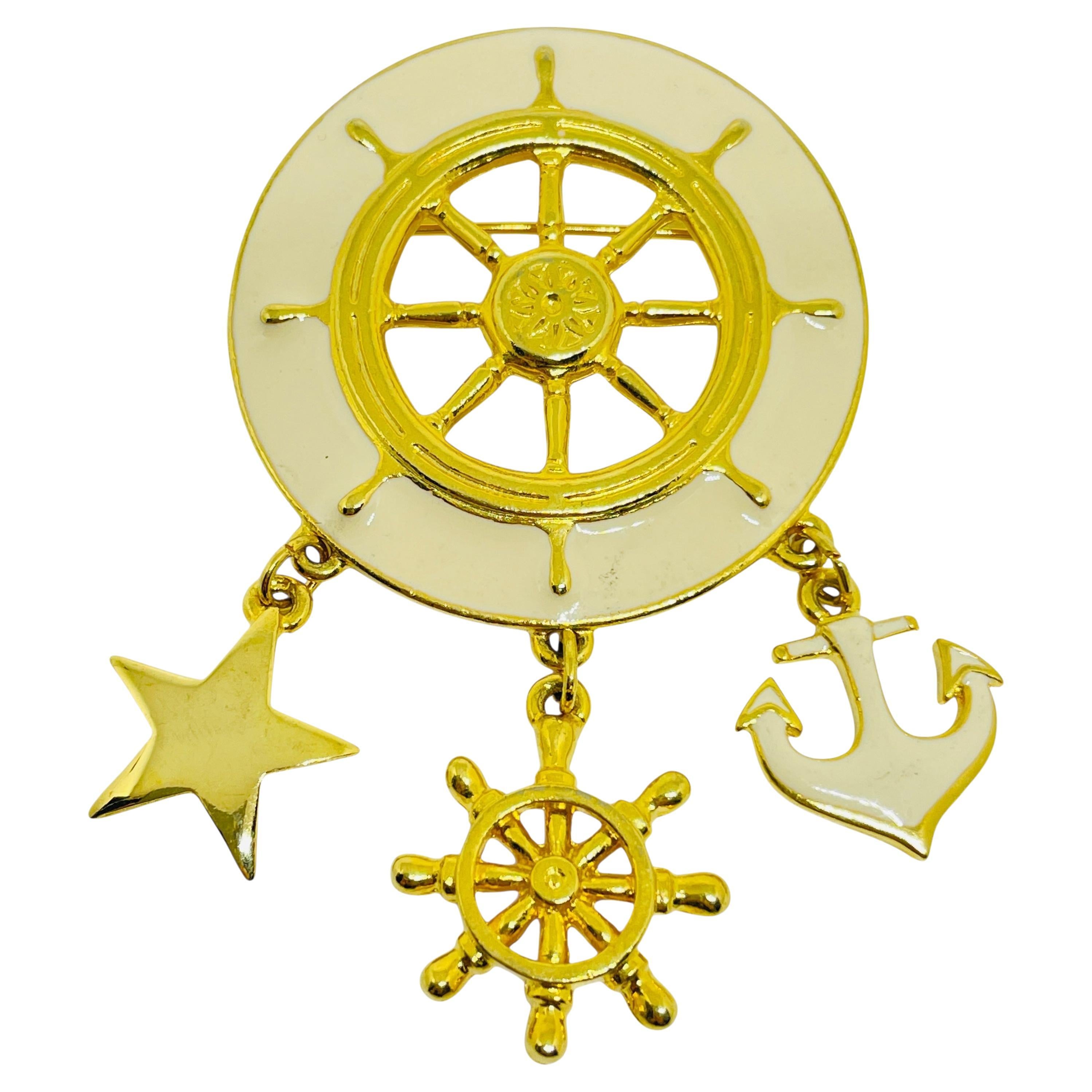 Broche vintage en émail doré avec pendentif nautique.