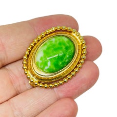 Broche vintage en verre vert doré de designer
