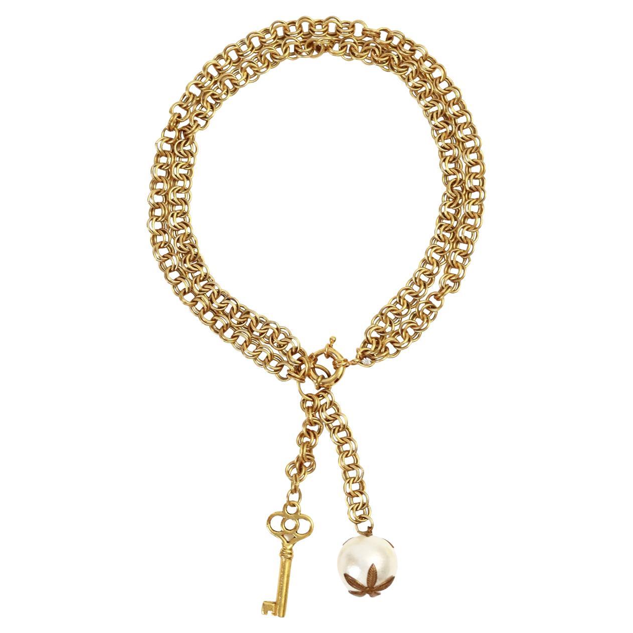Vintage Gold Tone Lariat Drop Key und Faux Pearl Halskette CIRCA 1980's.  Die doppelte Kette mit den schweren, herabbaumelnden Stücken verleiht ihr einen sehr antiken Touch und sie sieht einfach großartig aus.  Alle funktionierenden Teile sind ein
