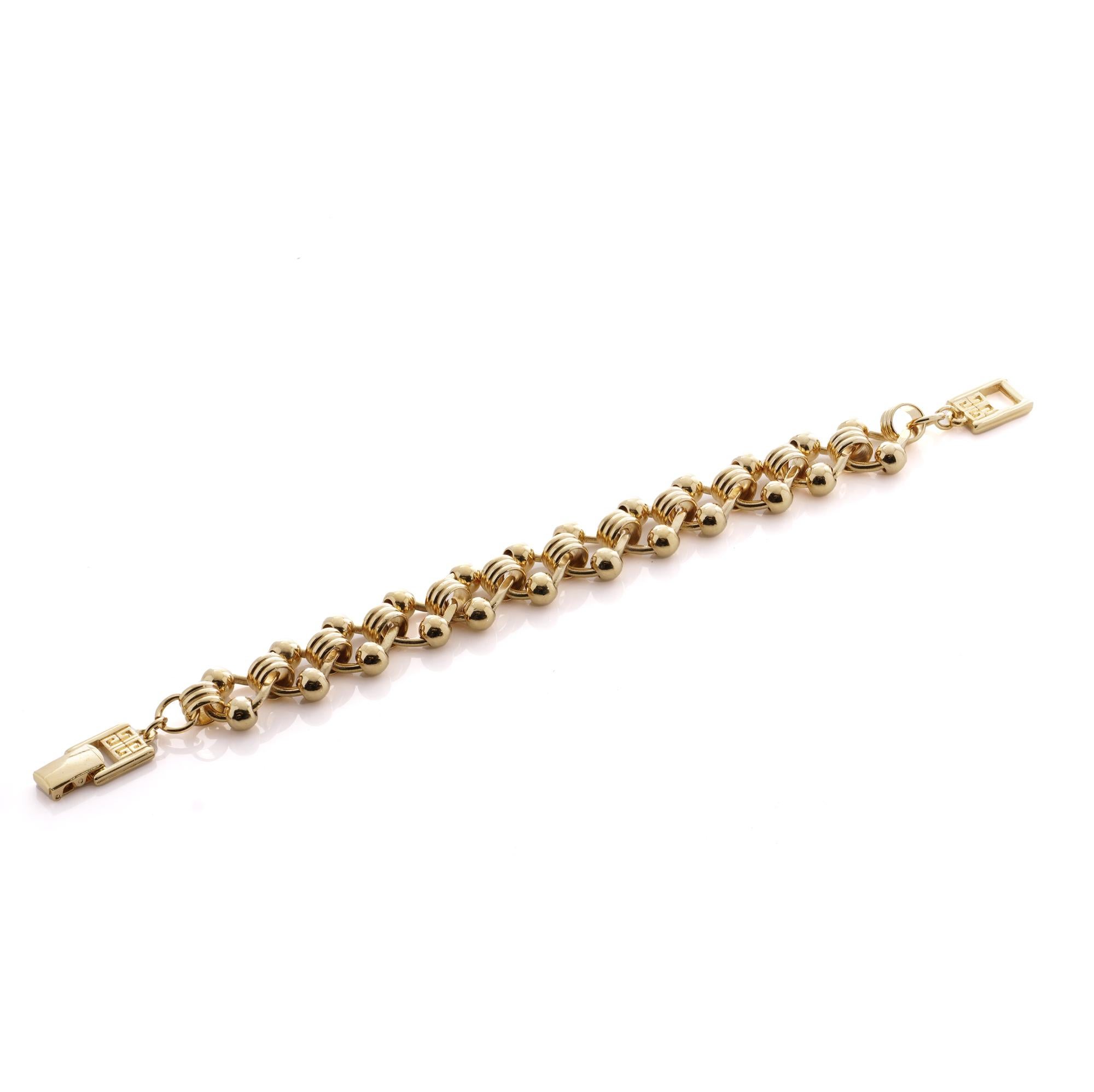 Voici une pièce d'élégance intemporelle de la célèbre maison Givenchy, le bracelet à maillons vintage en ton or, datant de la fin des années 1990. Réalisé avec une attention méticuleuse aux détails, ce bracelet exsude la sophistication et le