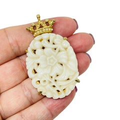 Ciondolo a forma di fiore modellato in tonalità oro con corona di perle finte di design.