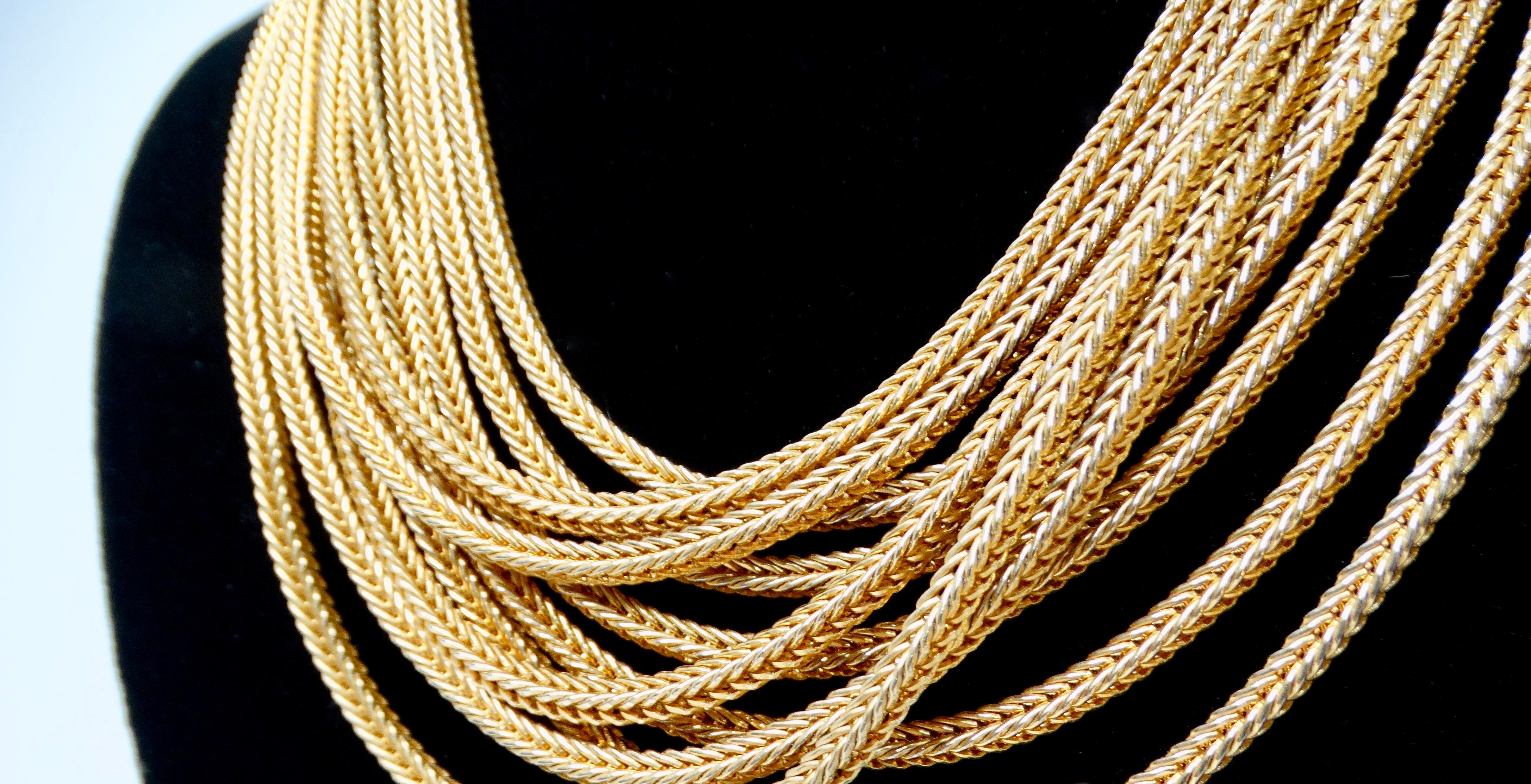 El Collar de Cadena de Cuerda en Capas de Varias Vueltas en Tono Dorado Vintage es un accesorio impresionante que encarna el encanto de la sofisticación atemporal. Esta exquisita pieza presenta múltiples hilos de cadenas de cuerda intrincadamente