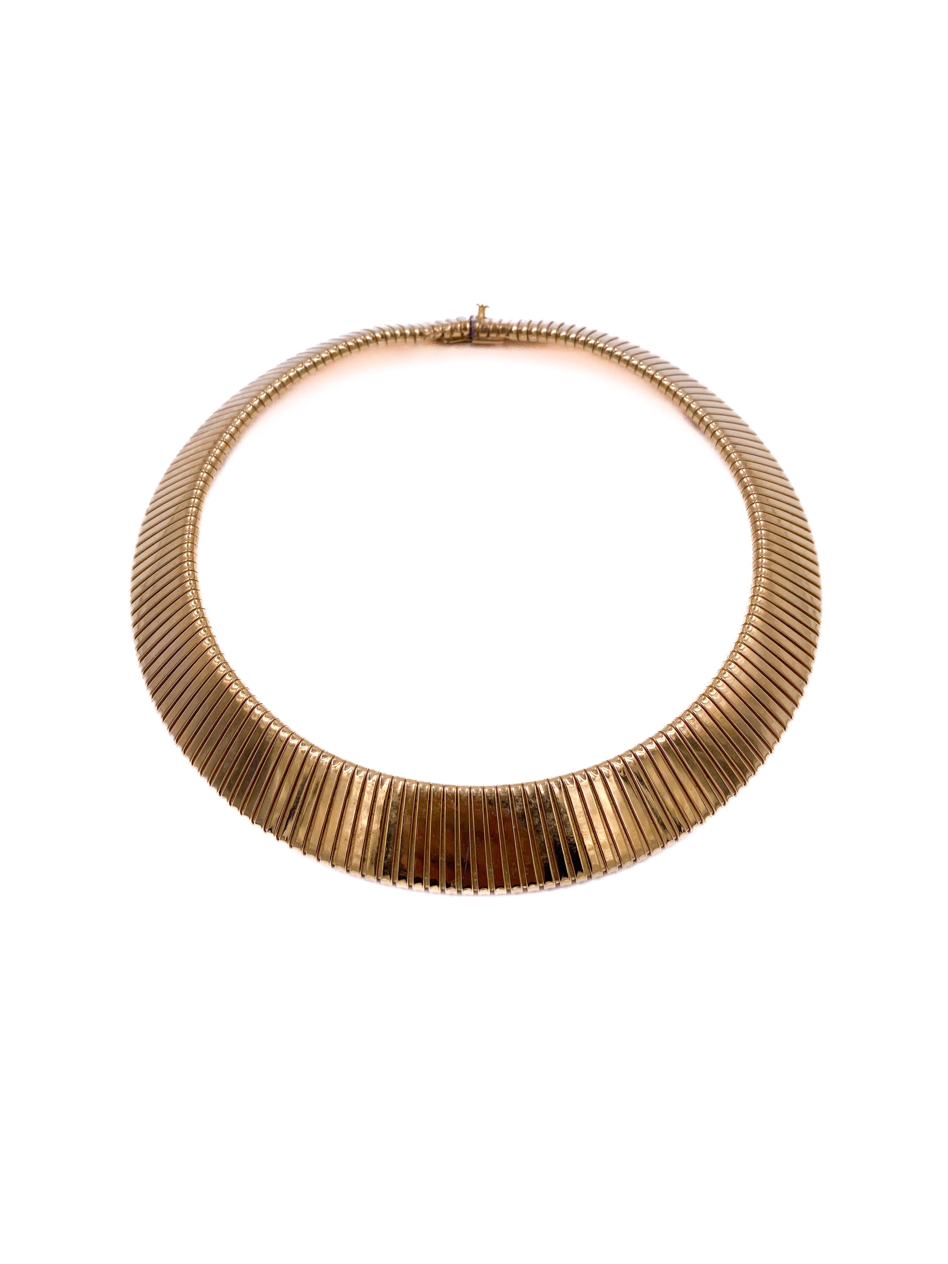This Vintage Gold Tubogas Necklace features a classic tubogas design crafted in a warm gold tone. Its choker length offers a timeless silhouette that sits elegantly at the neckline, making it a versatile accessory for both everyday wear and special