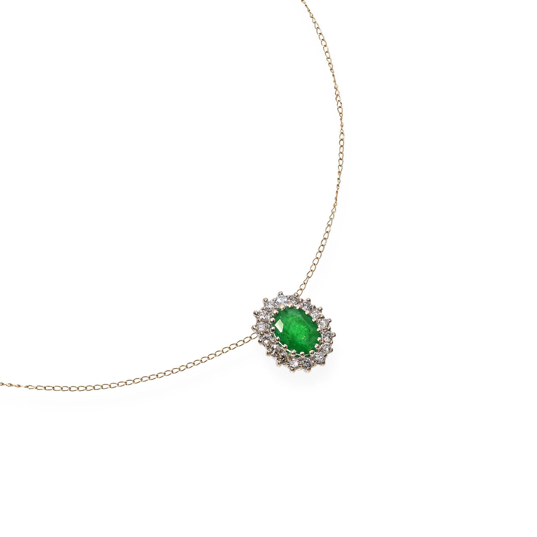 Una squisita collana con smeraldo e diamante. Presenta uno smeraldo ovale centrale con una ricca tonalità di verde. Lo smeraldo è circondato da diamanti rotondi con taglio a brillante che creano un effetto aureola. Il ciondolo è sospeso a una
