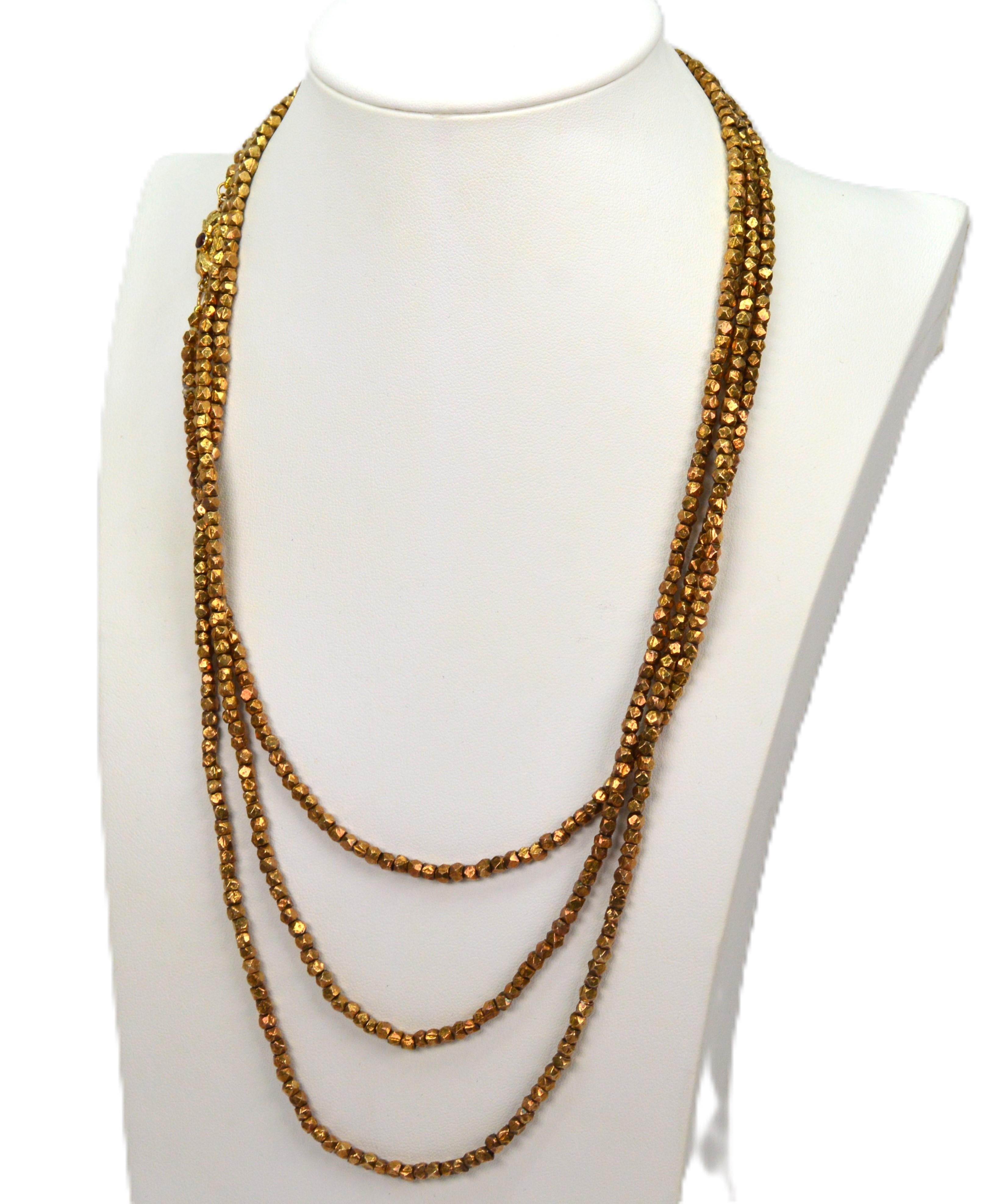 A unique vintage find, that pairs extraordinary necklace length and unique materials to create a one-of-a-kind piece. 
Sterling silver nugget shaped beads that are washed in yellow gold are hand-strung along this impressively long 64 inch necklace.