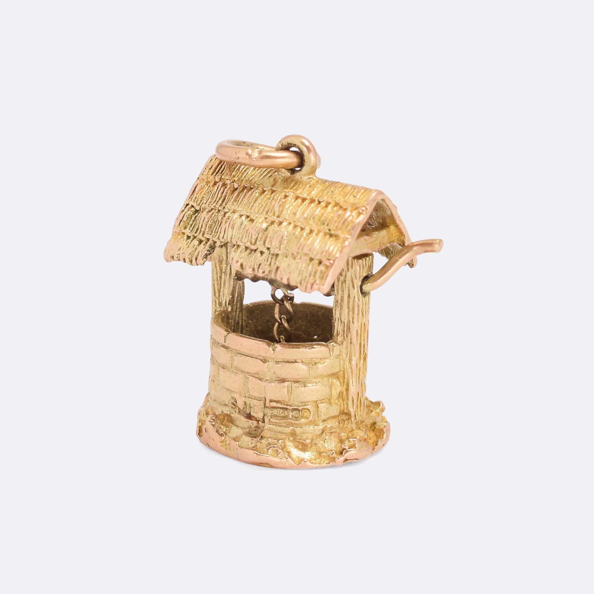 A fine 9k  gold wishing well charm dating from the 1970s. It features a working winding handle that lifts the bucket up and down. Offered on a fine 9k gold chain.

MEASUREMENTS 
1.5 x 2.2cm (width x height)

WEIGHT 
6.6g

MARKS 
English hallmarks