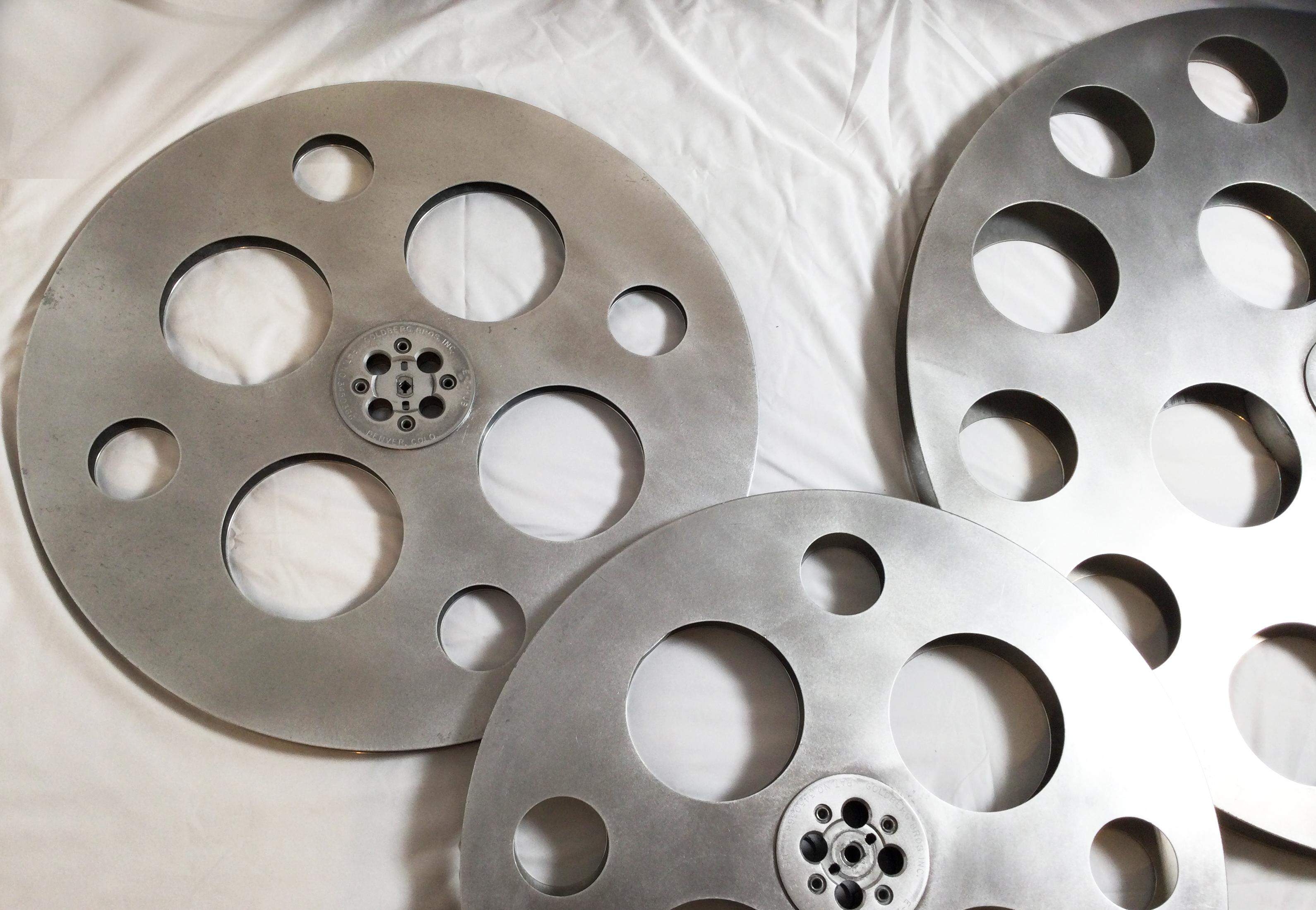 This is a collection of three movie reels in different sizes all manufactured by Goldberg Bros. Inc. The largest is nearly 36