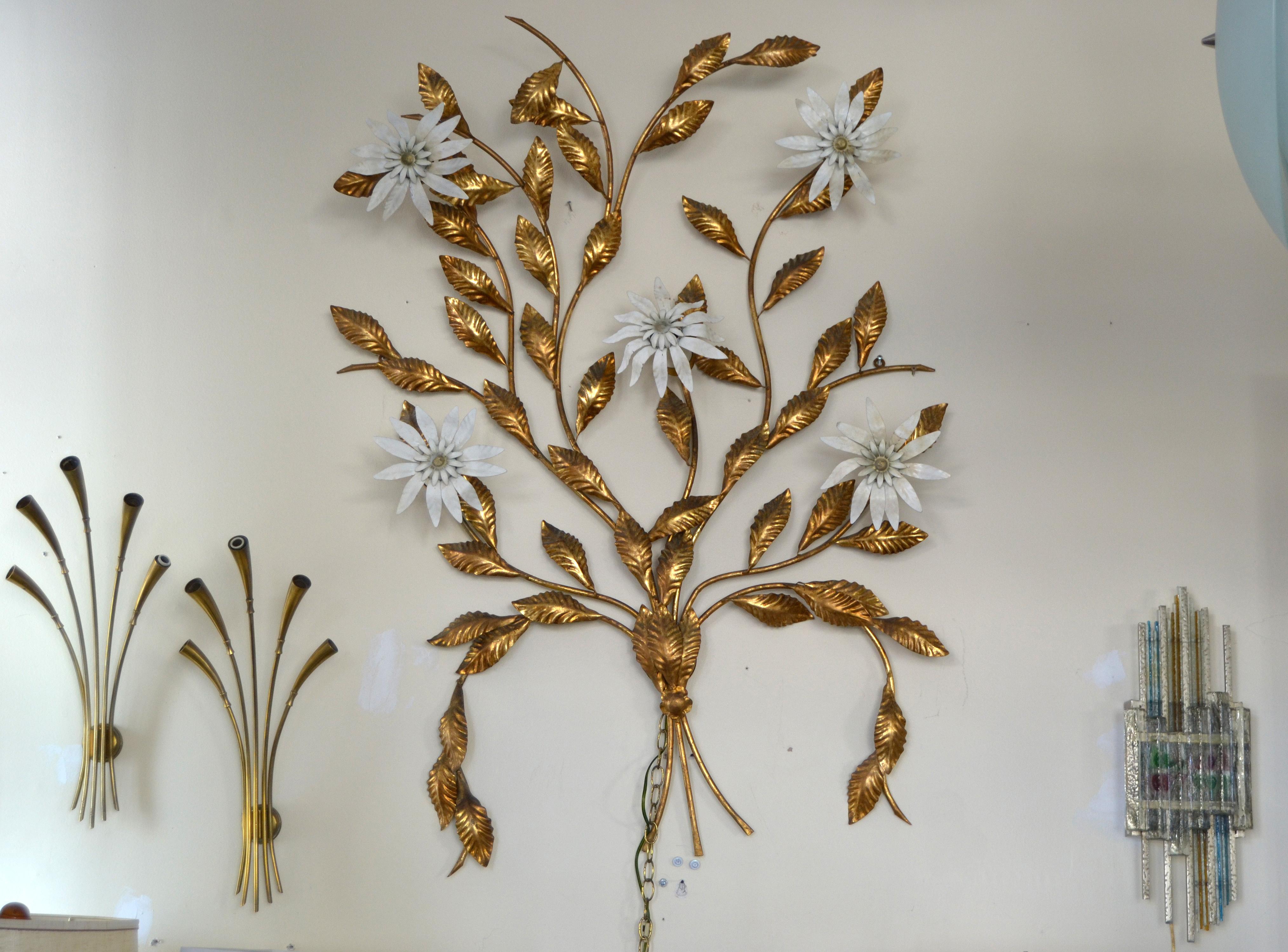 Vintage golden metal tree branch wall sculpture with 5 flower lights.
The flowers are made out of enamel and each uses a max. 40 watts light bulb.
The sculpture has a plug in connection and works perfectly.