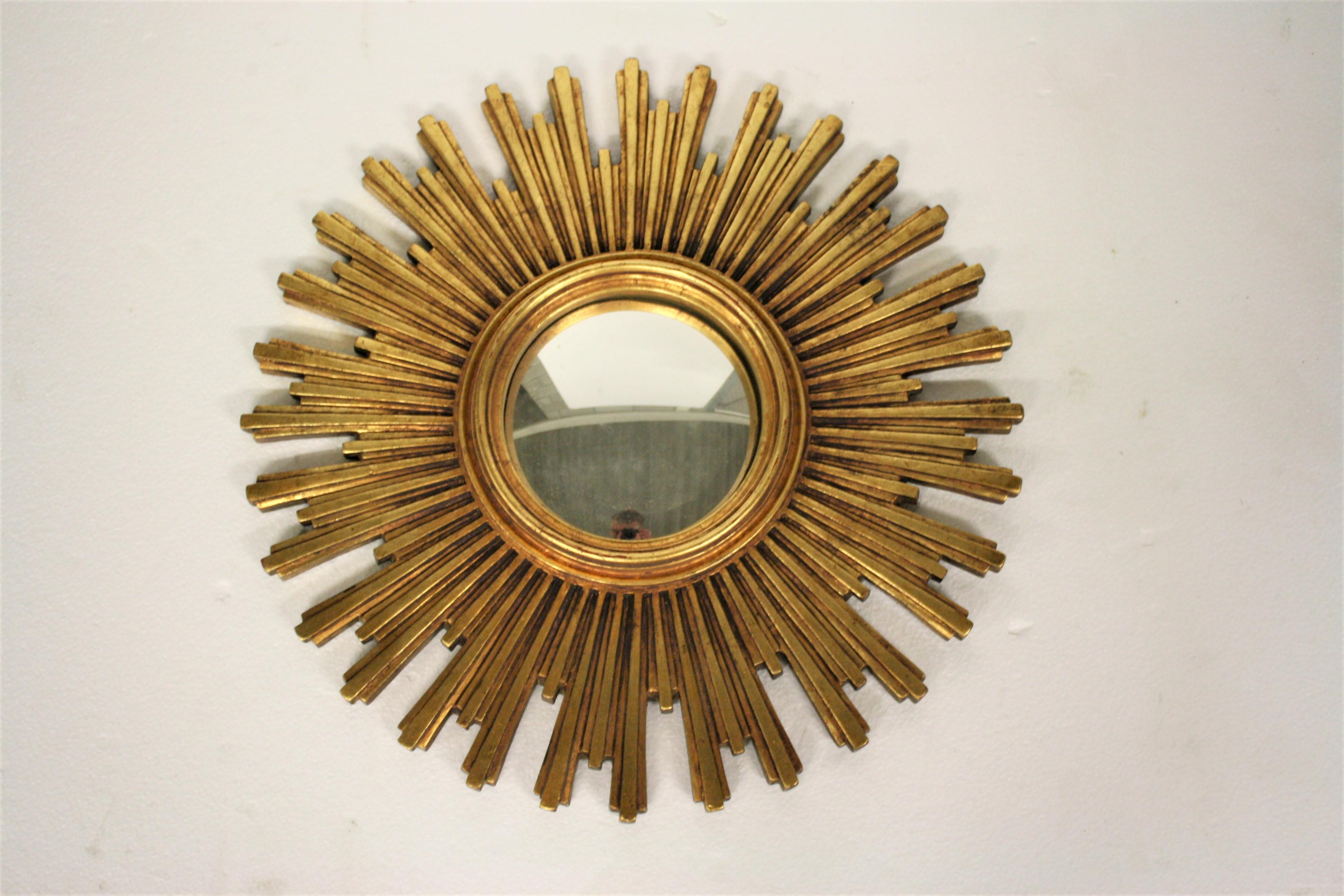 Heavy gilded resin sunburst mirror with convex mirror glass.

The golden mirror is in a very good condition.

Made in Belgium, 1960s.

Dimensions:
Diameter 56.5cm/22.04