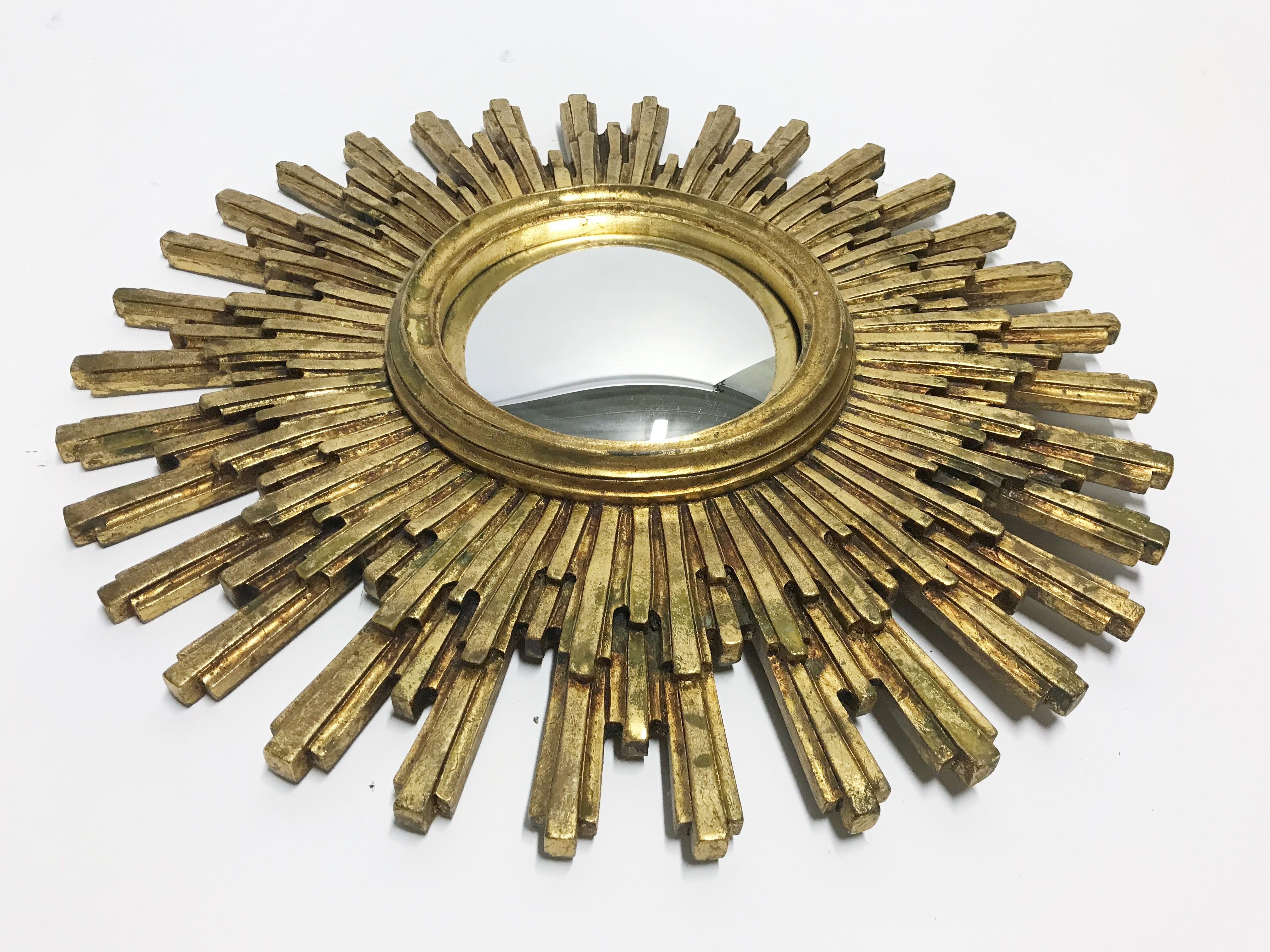 Heavy gilded resin sunburst mirror with convex mirror glass.

The golden mirror is in a very good condition, beautifully patinated.

1960s - made in Belgium.

Dimensions:
Diameter: 55 cm/ 21.6