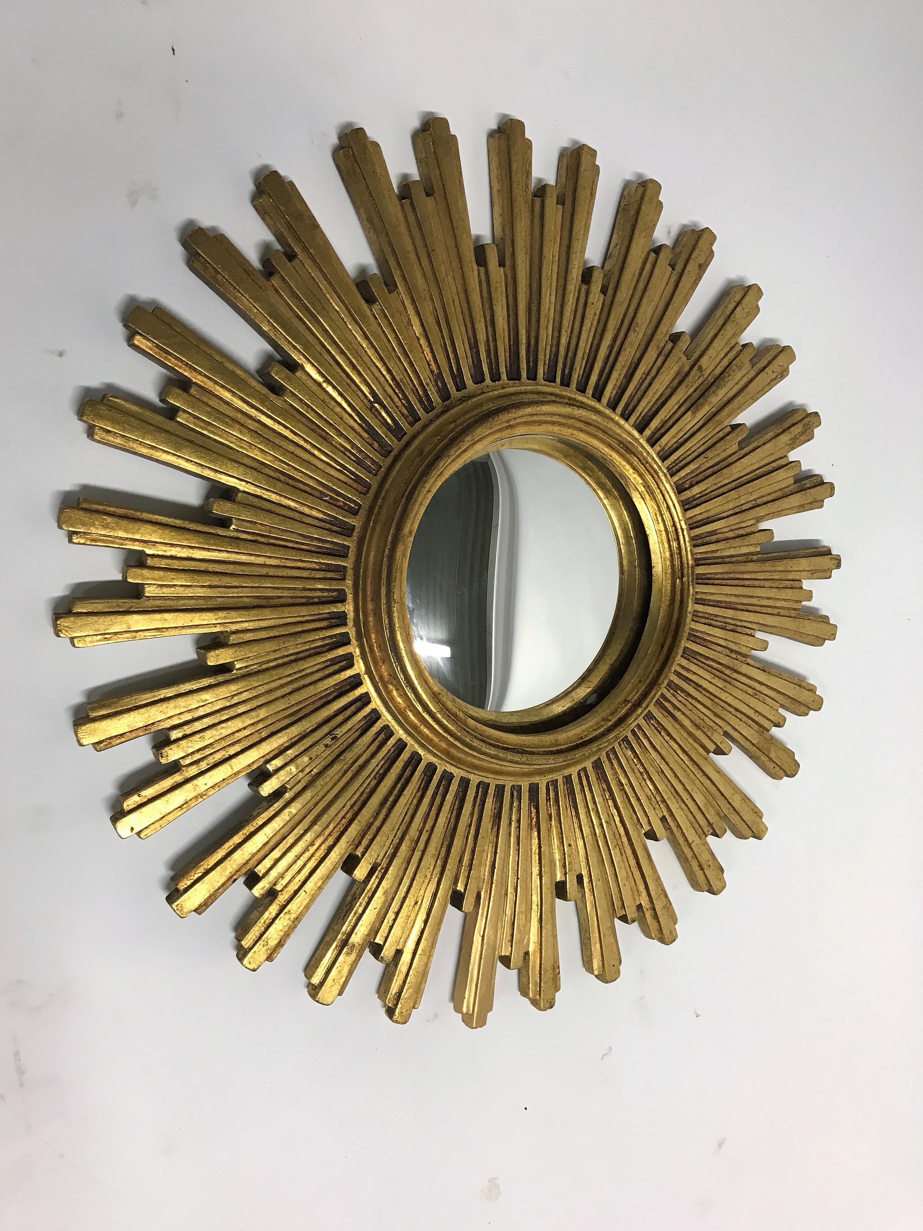 
Heavy gilded resin sunburst mirror with convex mirror glass.

The golden mirror is in a very good condition.

It has a near invisible repair on one of the 'sunrays'

1960s, made in Belgium.

Dimensions:
Diameter frame 54cm/21”
Diameter