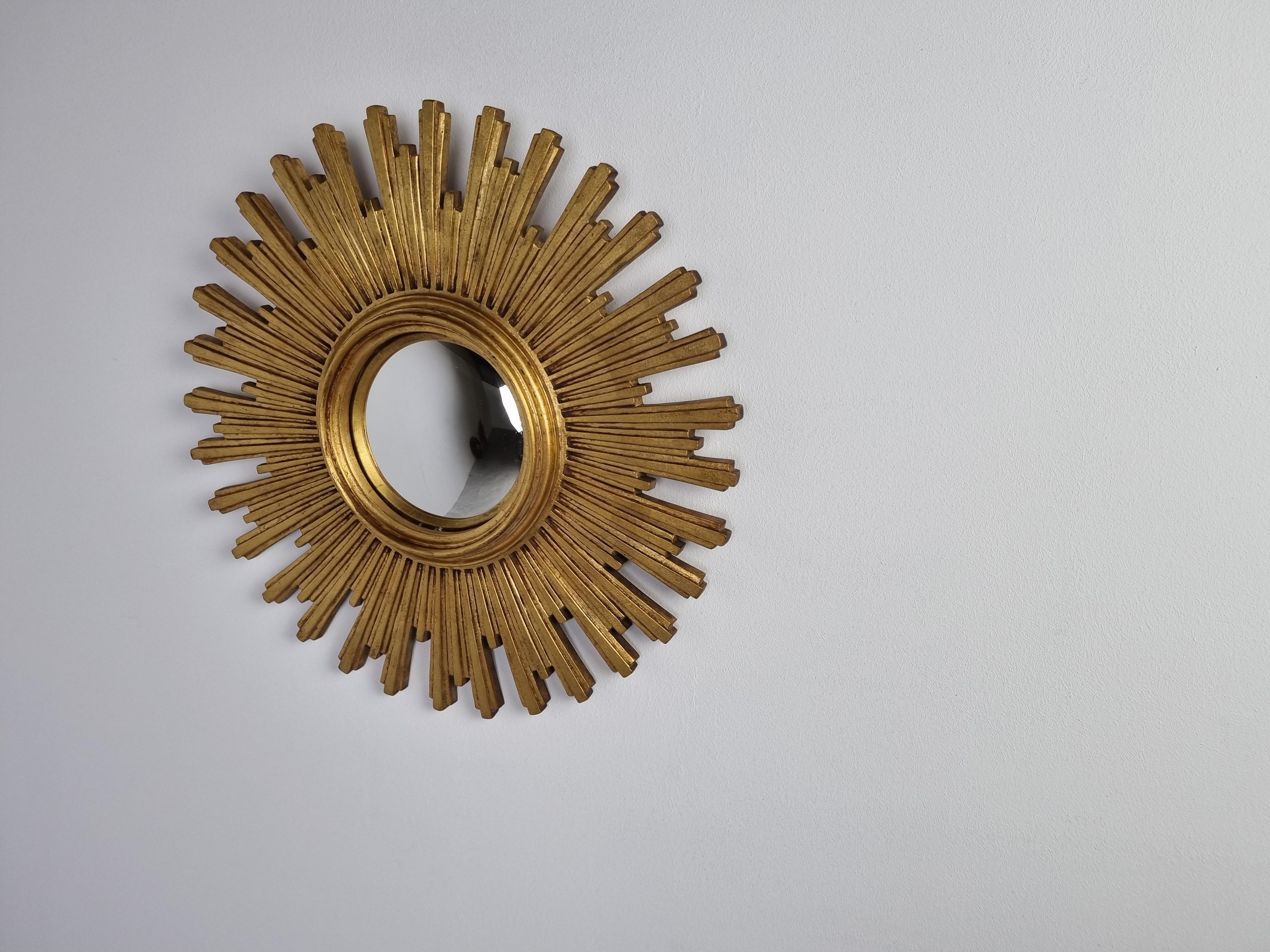 Heavy gilded resin sunburst mirror with convex mirror glass.

The golden mirror is in a good condition.

1960s - made in Belgium.

Dimensions:
Diameter: 55cm/ 21.6