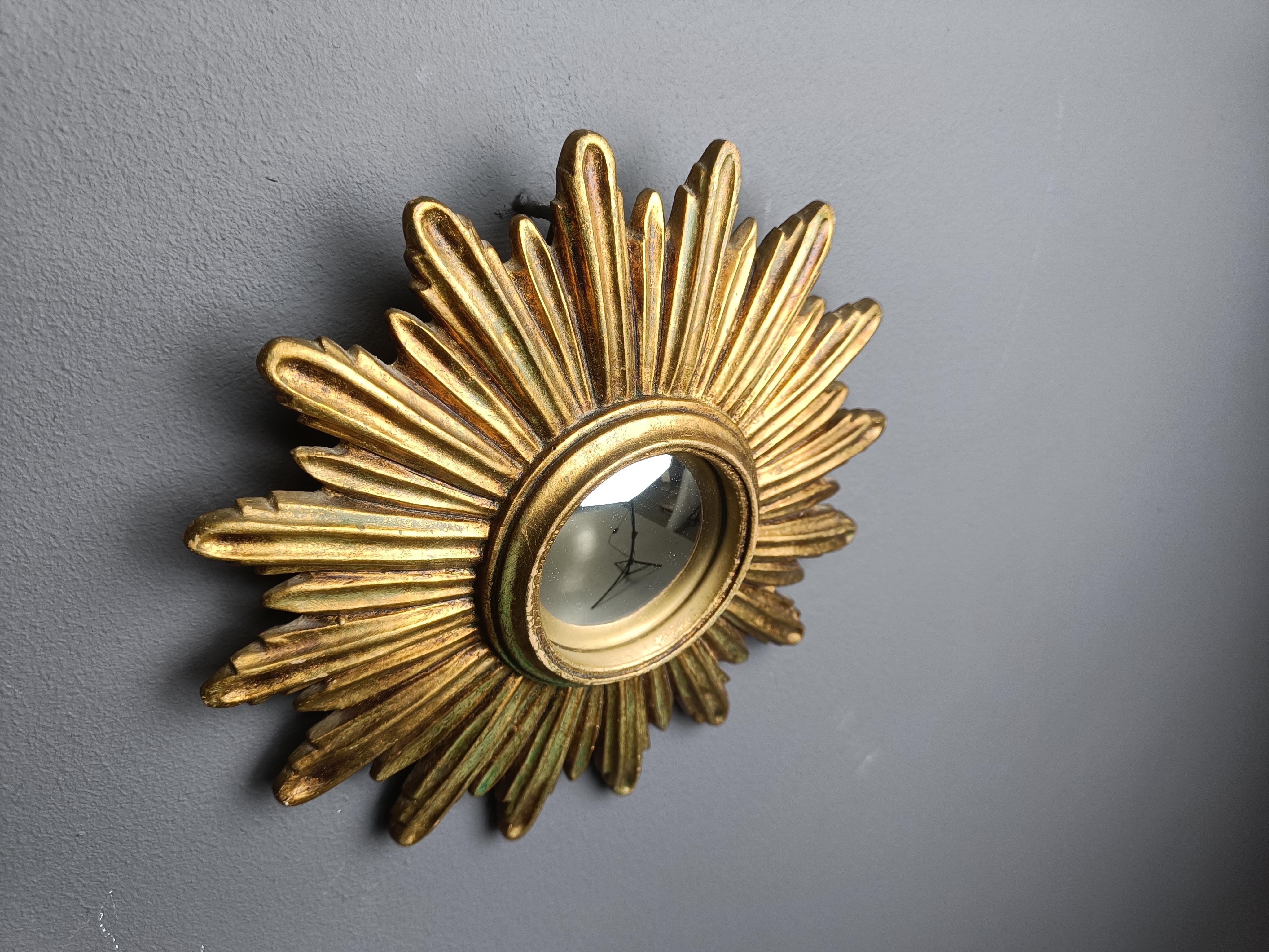 Specchio a raggiera in resina dorata con vetro a specchio convesso.

Lo specchio d'oro è in buone condizioni.

Anni '60 - prodotto in Belgio.

Dimensioni:
Diametro: 28 cm

Rif:  87456412 60