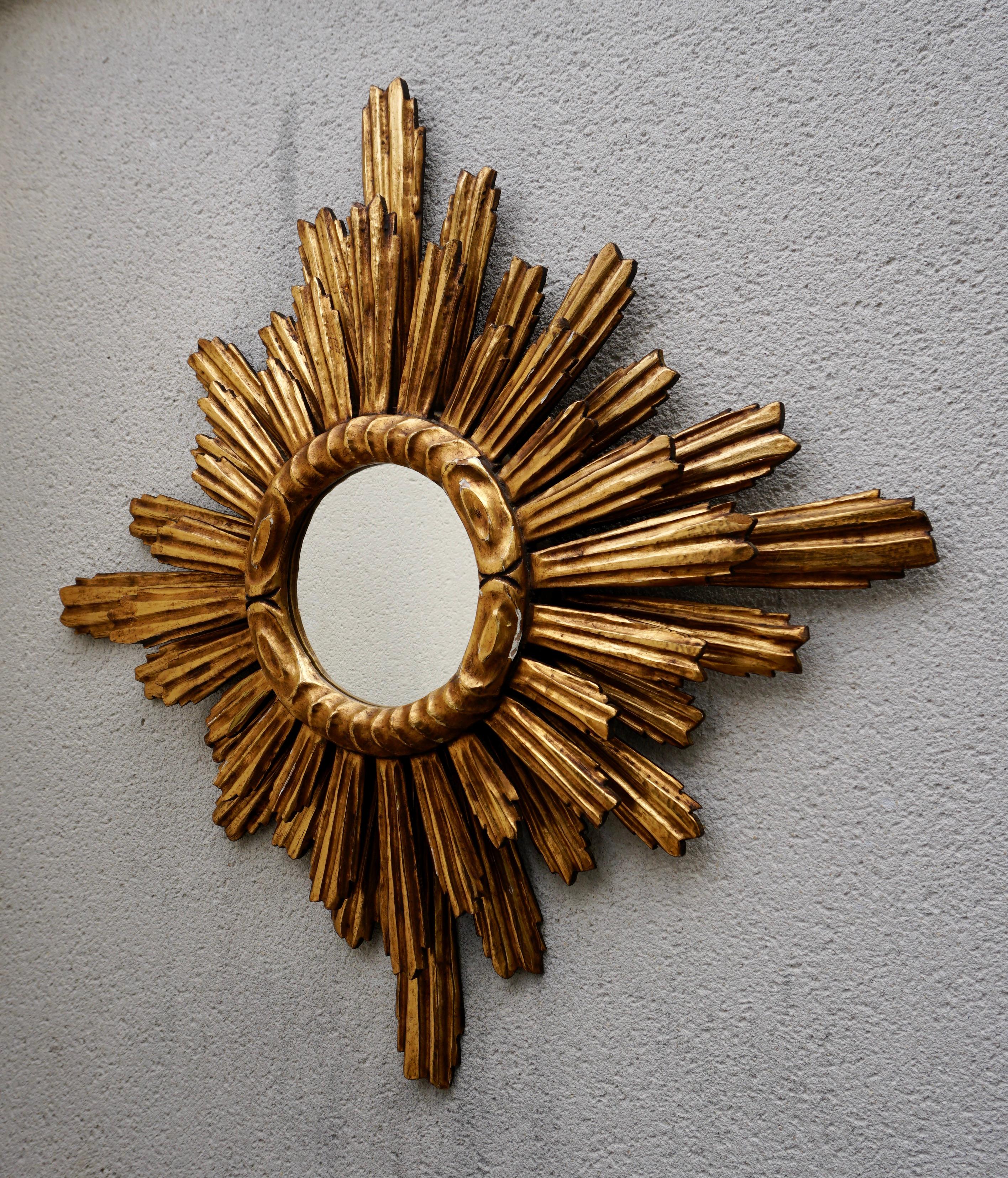 A gorgeous sunburst mirror. Made of gilded wood and in good vintage condition. 
It measures  31.4
