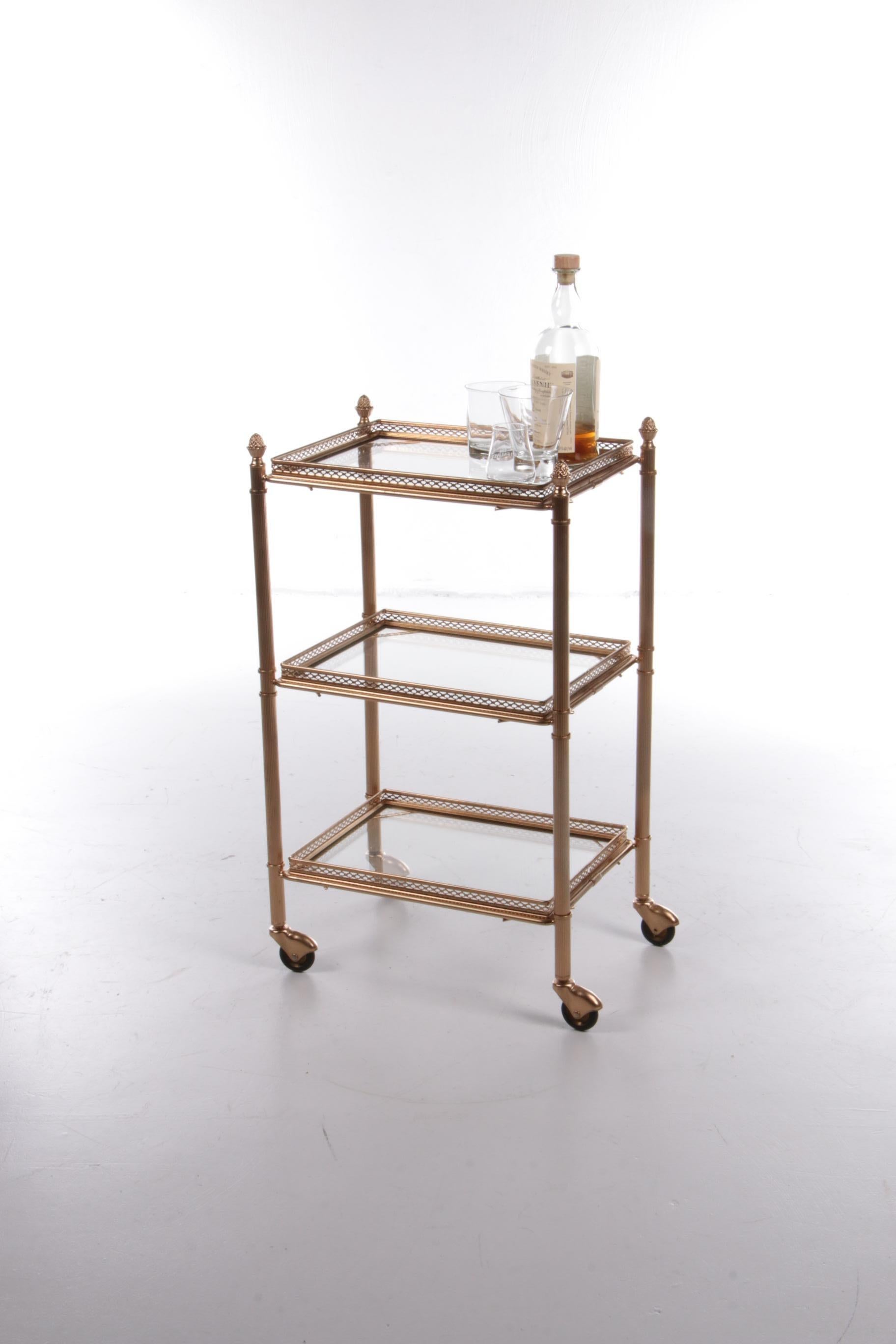 Brass serving trolley/tea trolley vintage with three layers.

Nice elongated shape with a brass frame and glass plates. The top and bottom trays are removable and can also be used as a tray.

Still in top condition, it still looks great for its