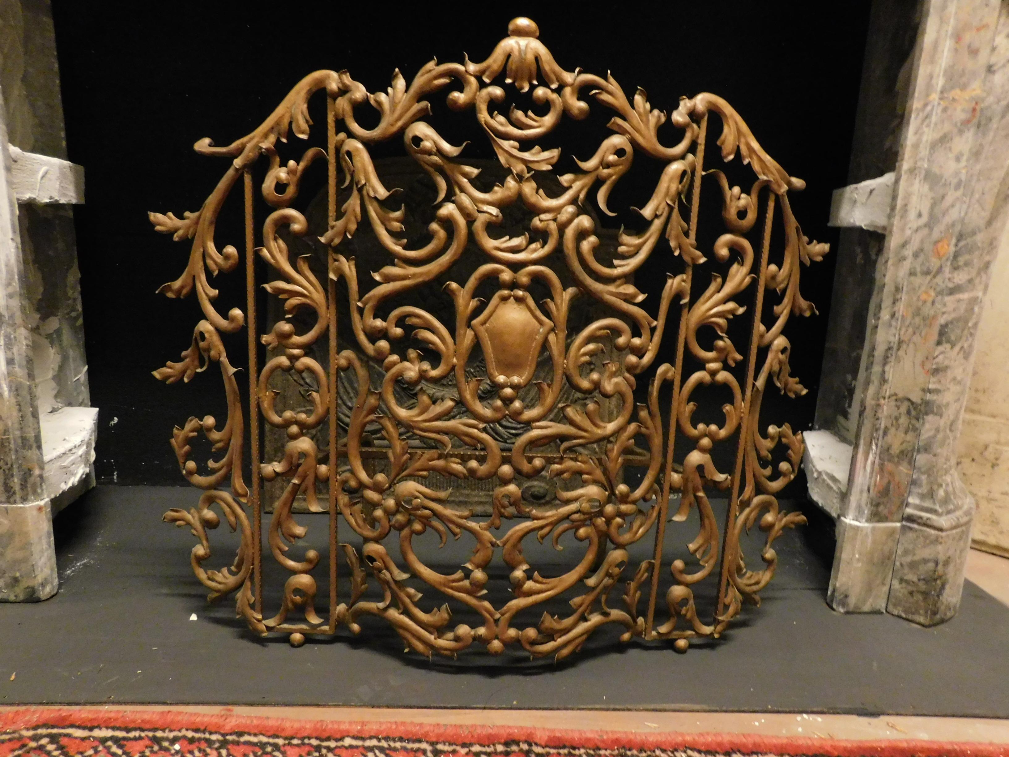 Vintage spark arrestor, richly carved in wrought iron, gilded and pierced, built for rich fireplace in the 20th century, in Italy.
Rich, elegant and refined, suitable for decorating even the oldest fireplaces or for use in an imaginative