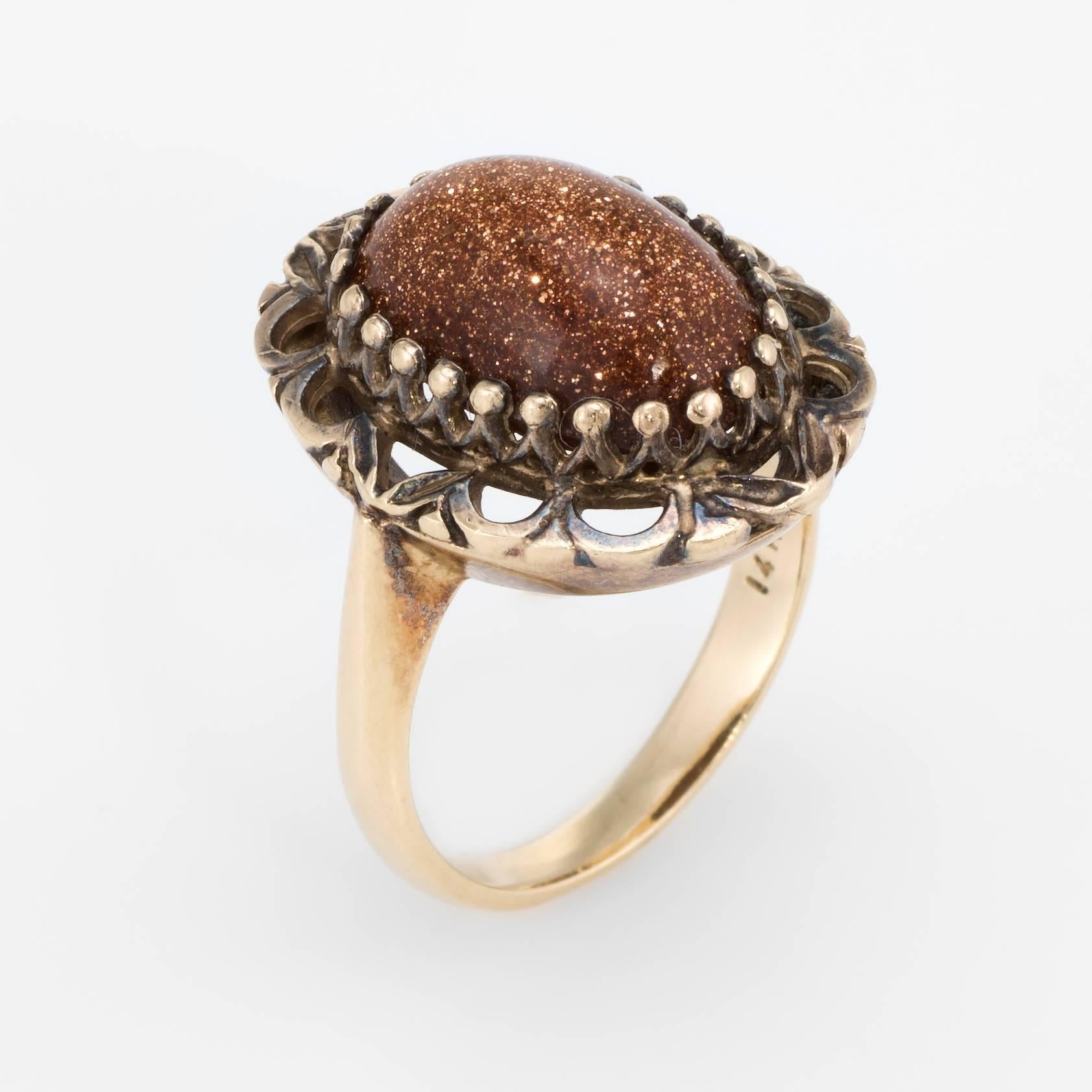 Finely detailed vintage cocktail ring (circa 1960s), crafted in 14 karat yellow gold. 

Cabochon cut goldstone measures 13mm x 9mm. The stone is in excellent condition and free of cracks or chips. The goldstone exhibits a glitter in shades of brown