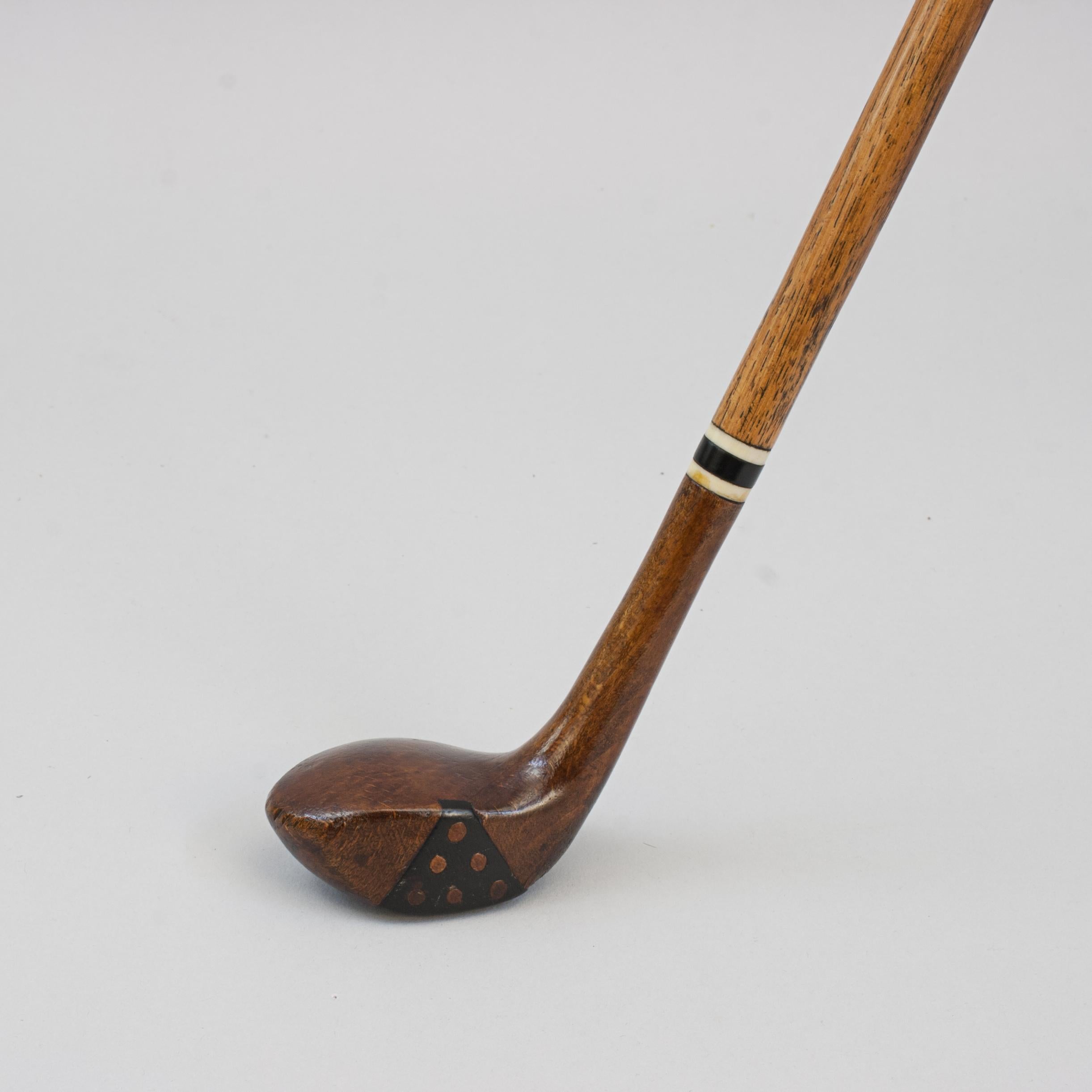 Antiguo palo de golf, bastón de palo de golf.
Un deseable bastón con el mango en forma de cabeza de palo de golf. El bastón de caballero tiene una empuñadura de cabeza hueca de caqui con una suela curvada con inserción de clavijas en la cara y un