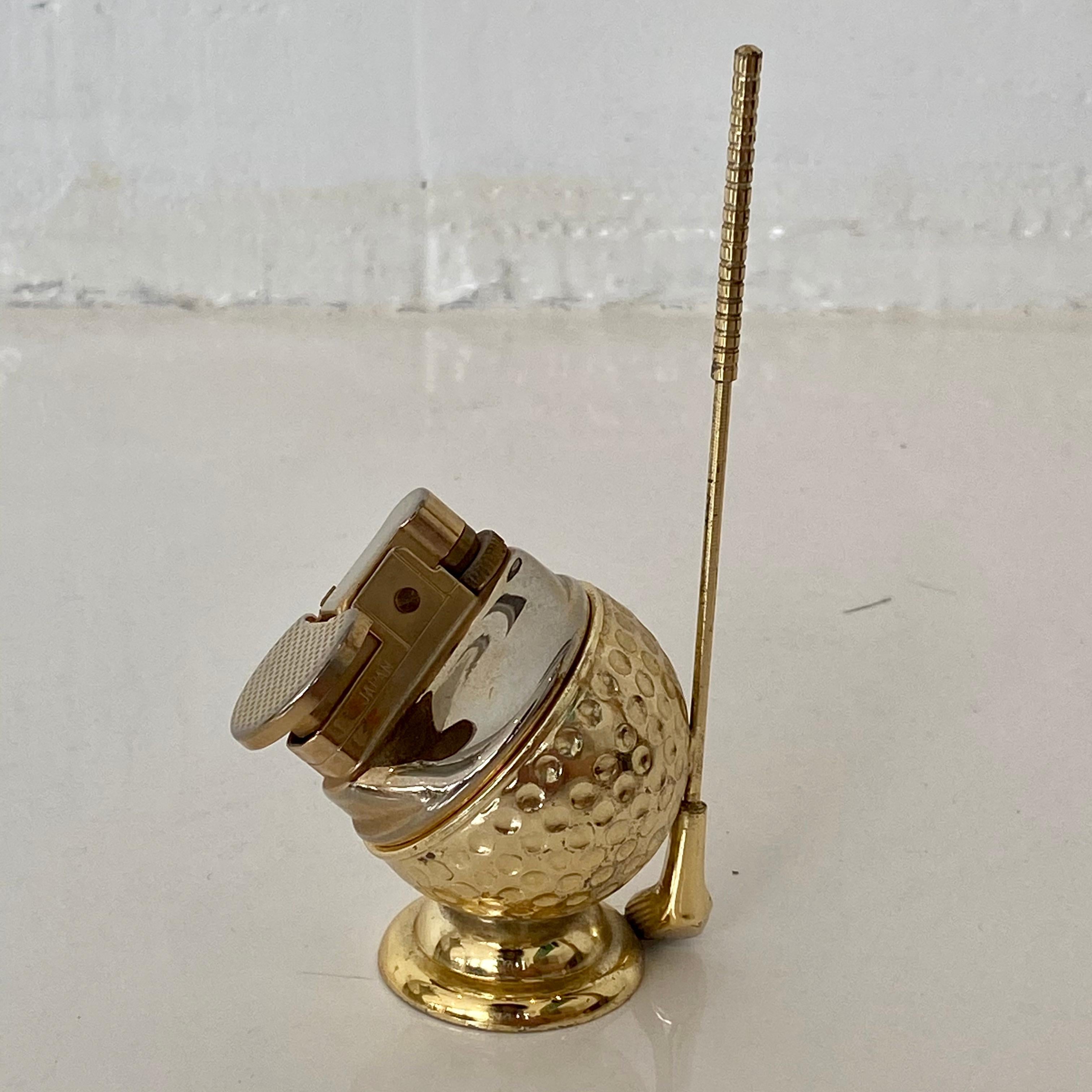 Cool vintage table lighter in the shape of a golfball and club. Made of metal. Label at bottom reads 