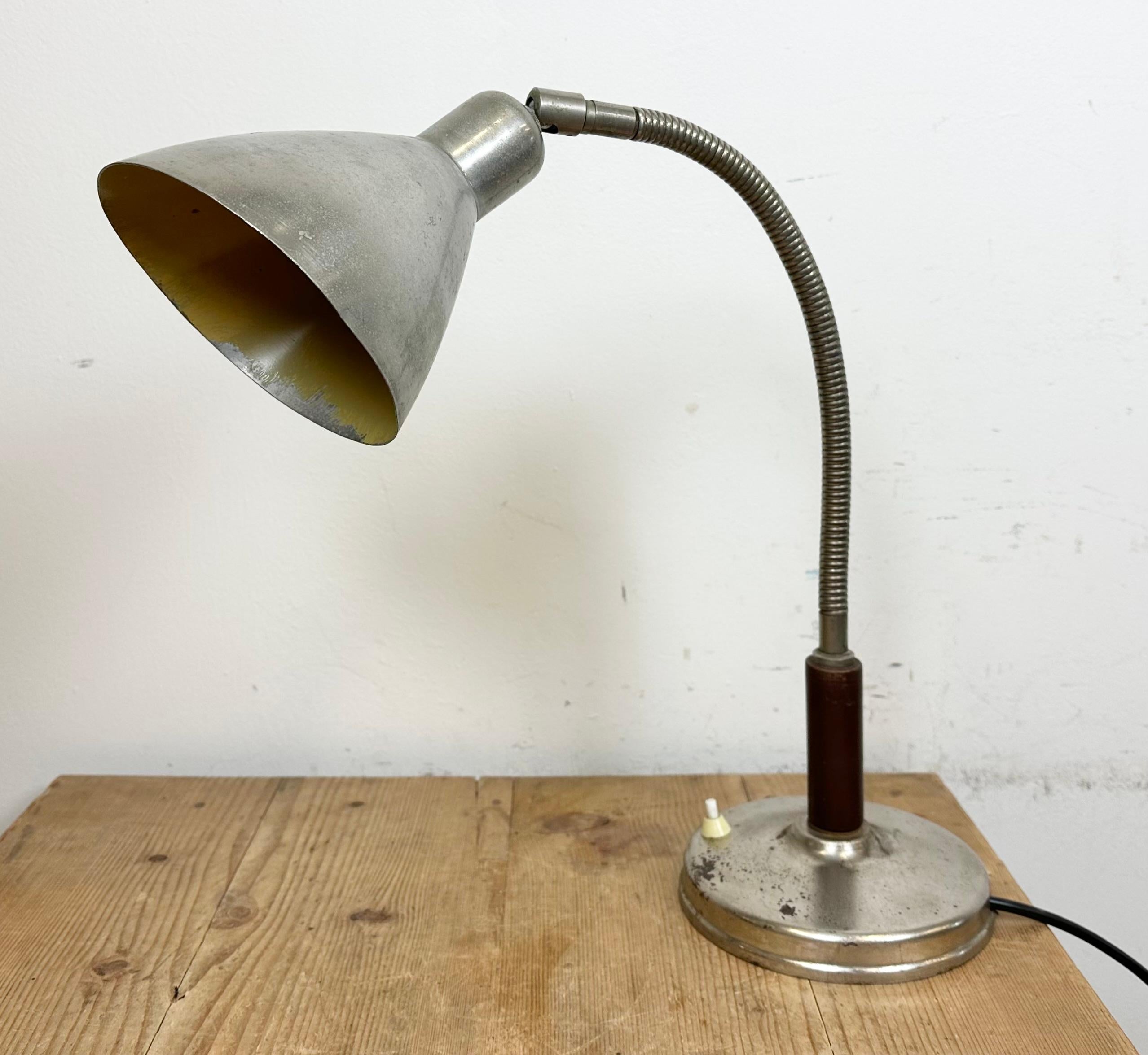 Vintage industrial adjustable table lamp made in former Czechoslovakia during the 1950s It features an aluminium shade and a chrome plated base and arm with wooden handle The original socket requires standard E27/E26 lightbulbs. New wire.
The