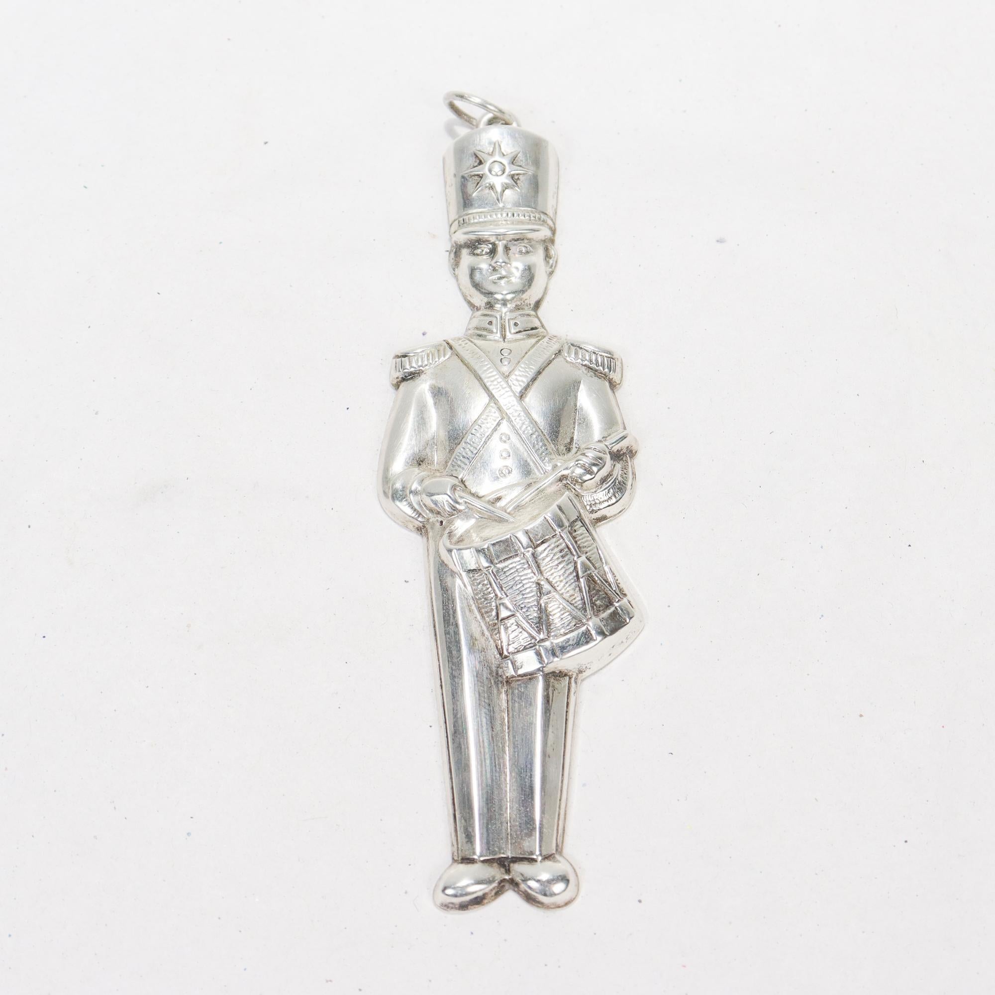 A fine vintage Christmas ornament of a drummer.

By Gorham Co.

In sterling silver.

Model no. 80.

In the form of a (toy?) soldier playing the snare drum. Set with a bail for hanging attached to the top of his hat.

Simply a great sterling silver