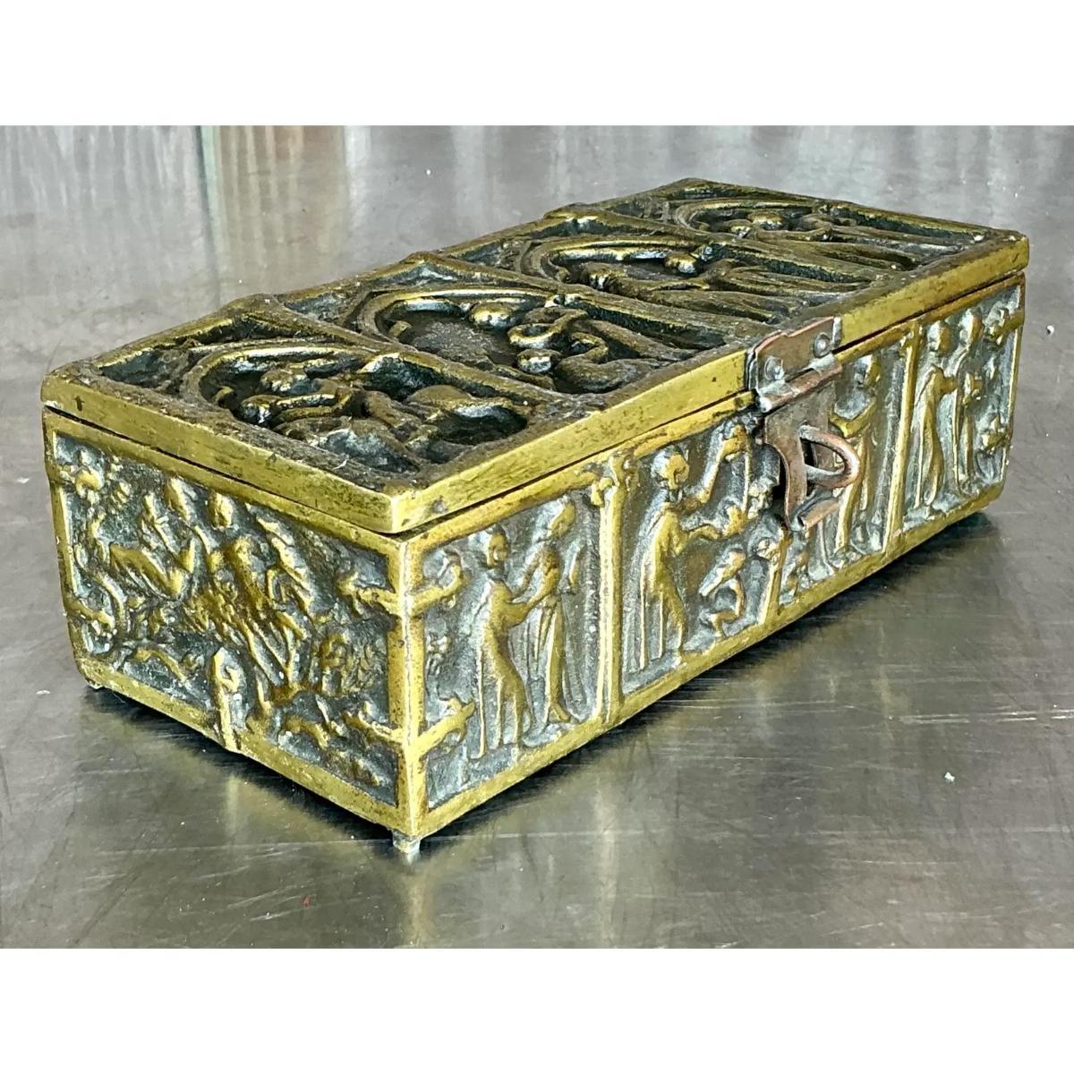 Aggiungi un tocco di misticismo medievale al tuo arredamento con questa scatola gotica vintage in ottone figurato. Realizzata in ottone massiccio, questa sorprendente scatola presenta intricati dettagli di ispirazione gotica con motivi figurativi