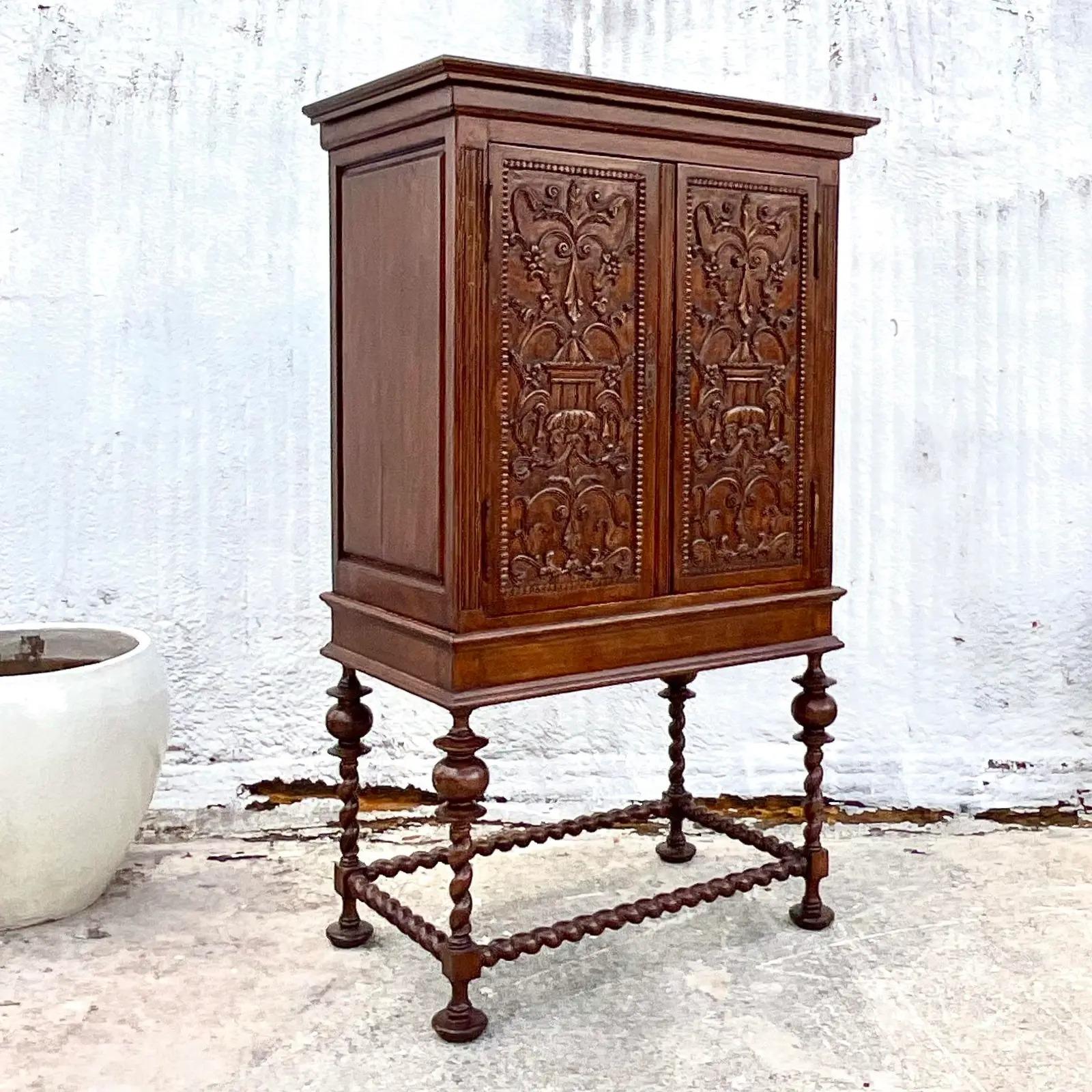 Fantastic vintage Barley twist armoire. Stunning hand carved detail on the cabinet. Top rests on chic Barley Twist pedestal. Lots of great interior storage. Would make an incredible dry bar. Acquired from a Palm Beach estate.