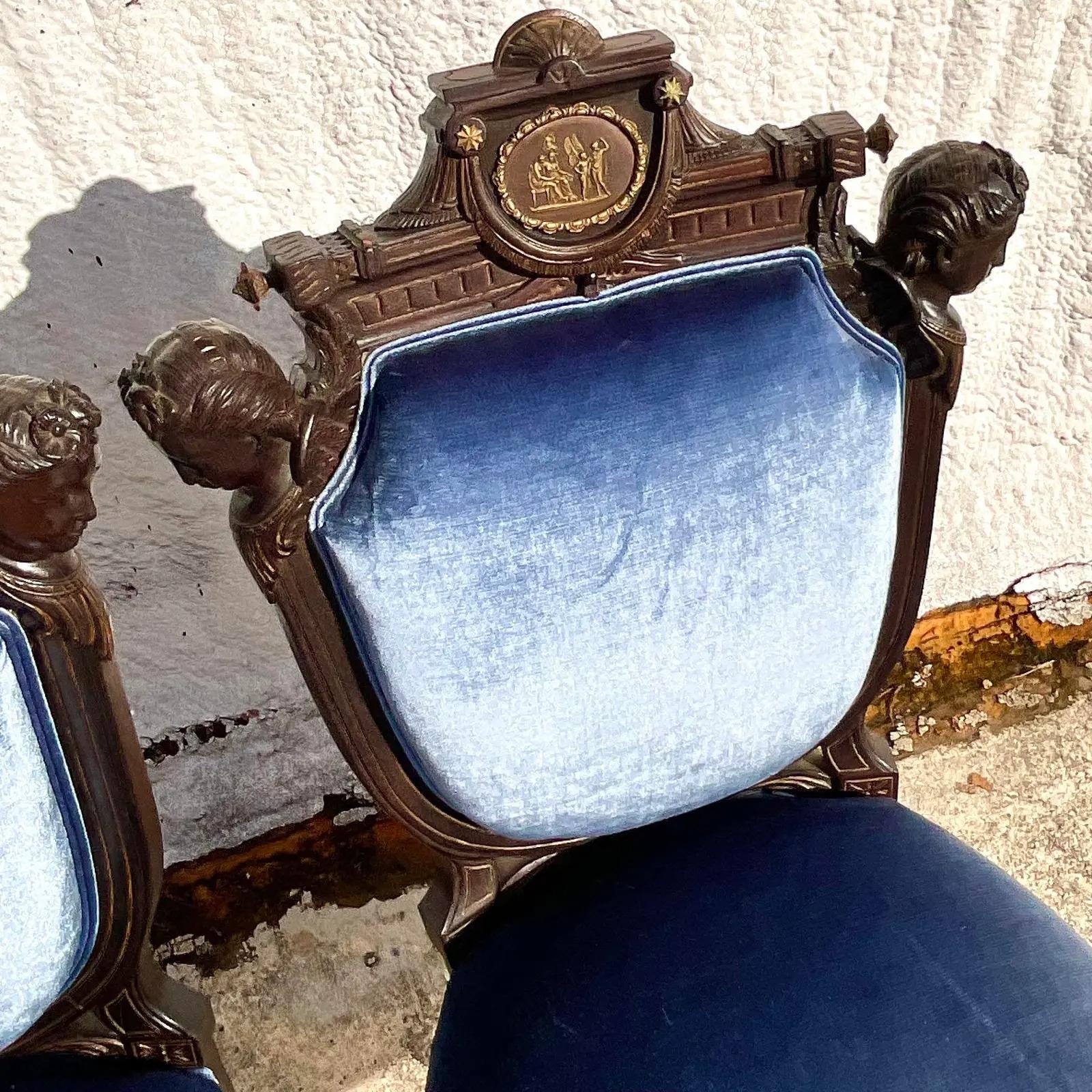 Una fantastica coppia di sedie laterali Boho vintage. Puttane intagliate a mano con splendidi dettagli in foglia d'oro. Sedute in velluto blu smerigliato con schienale metallico a contrasto. Acquistato da una proprietà di Palm Beach.

Le sedie sono