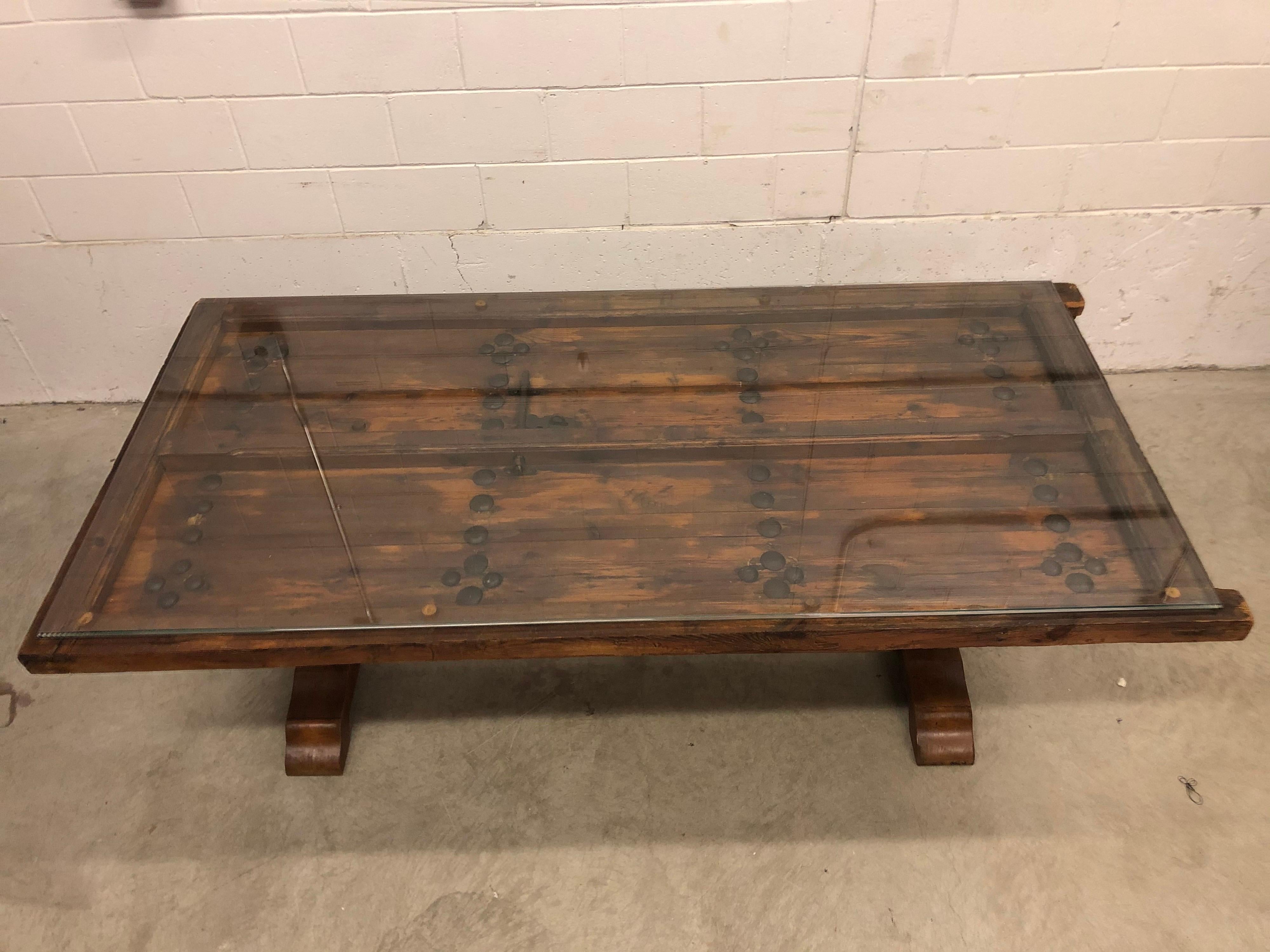 Vintage Gothic recycled door dining room table with glass top. The door has beautiful iron accents and door retains all the hand carved details that can be seen under the glass top. Great conversation piece for entertaining!