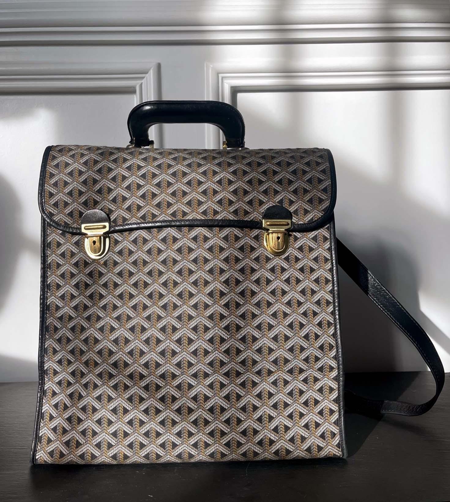 A vintage crossbody type Goyard bag with its iconic chevron printed canvas, leather trims and brass hardware circa post 1965 when the flexible canvas was introduced, likely from 1970-80s. The bag has a streamer rectangular shape, but it is