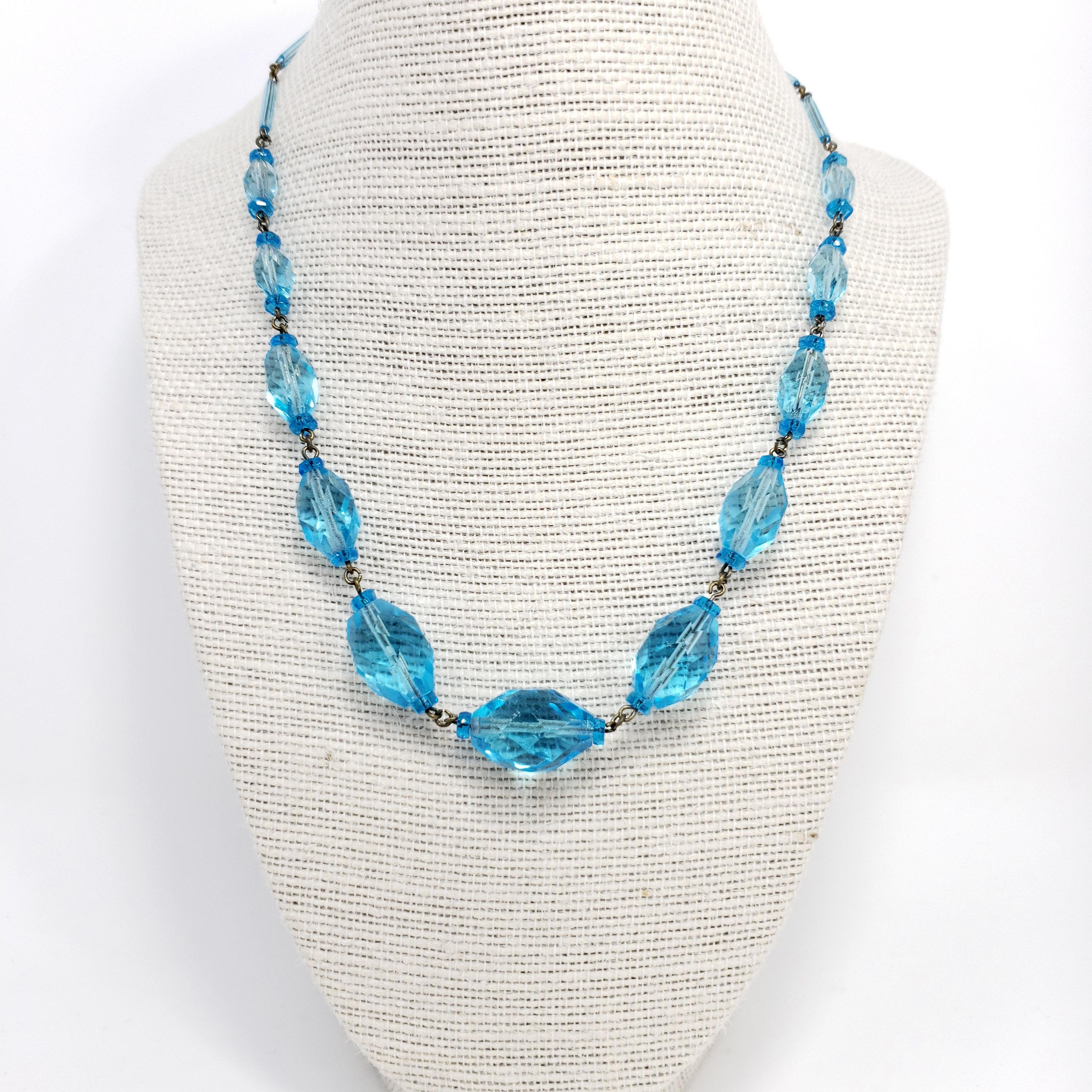 A vintage natural crystal necklace in an elegant icy blue aquamarine tone. Brass-tone chain and spring-ring clasp closure.

