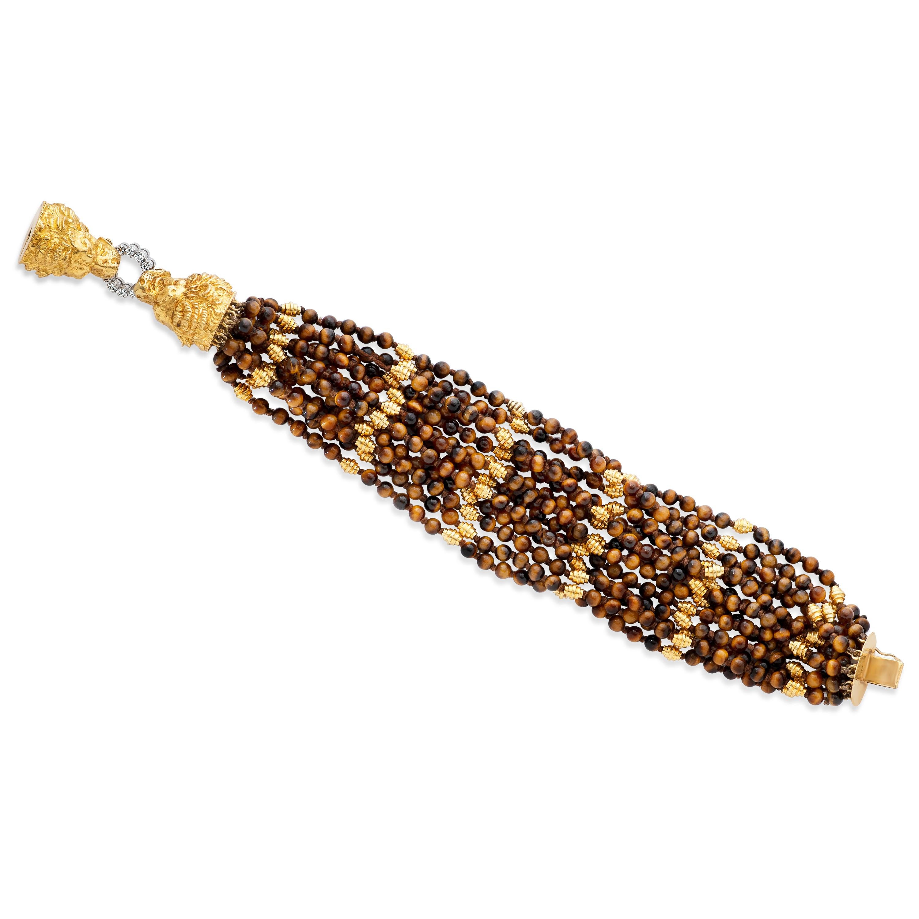 Vintage Graff multi-strand tiger's eye bead bracelet with 18k yellow & 18k white gold diamond accented double lion head clasp.

This unique bracelet features 13 strands of 4mm tiger's eye beads with 18kyg accents. The strands come together at two