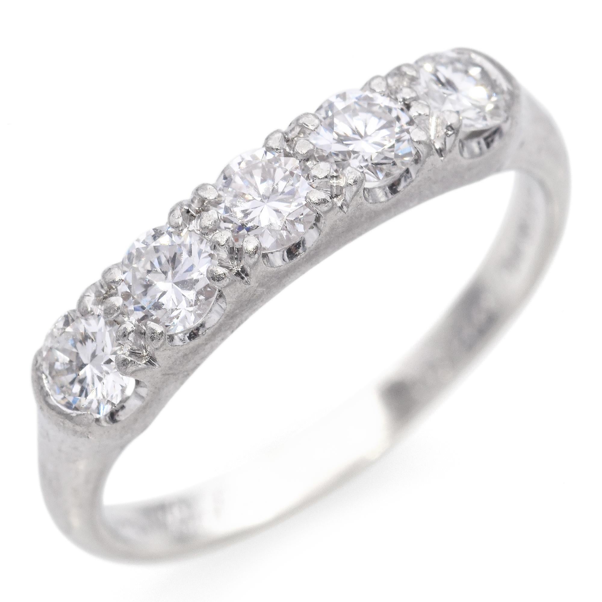 Elegant diamond band ring crafted in platinum. The ring features a row of round brilliant cut diamonds, each set in a shared prong setting. The diamonds are closely set, creating a continuous sparkle across the band. The ring has a smooth, polished