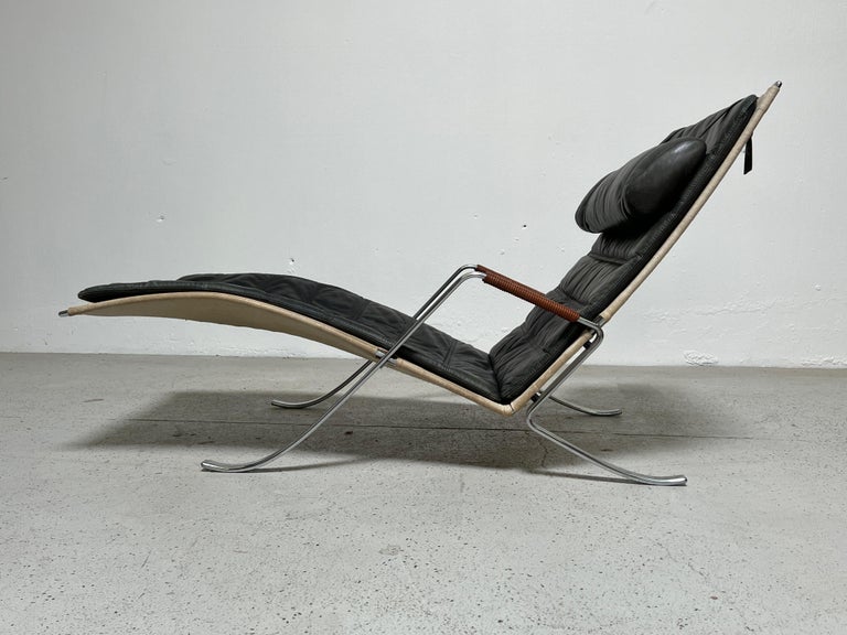 A vintage grasshopper chaise lounge by Preben Fabricius and Jørgen Kastholm for Kill International. Beautifully patinated leather that's worn to a greenish hue.