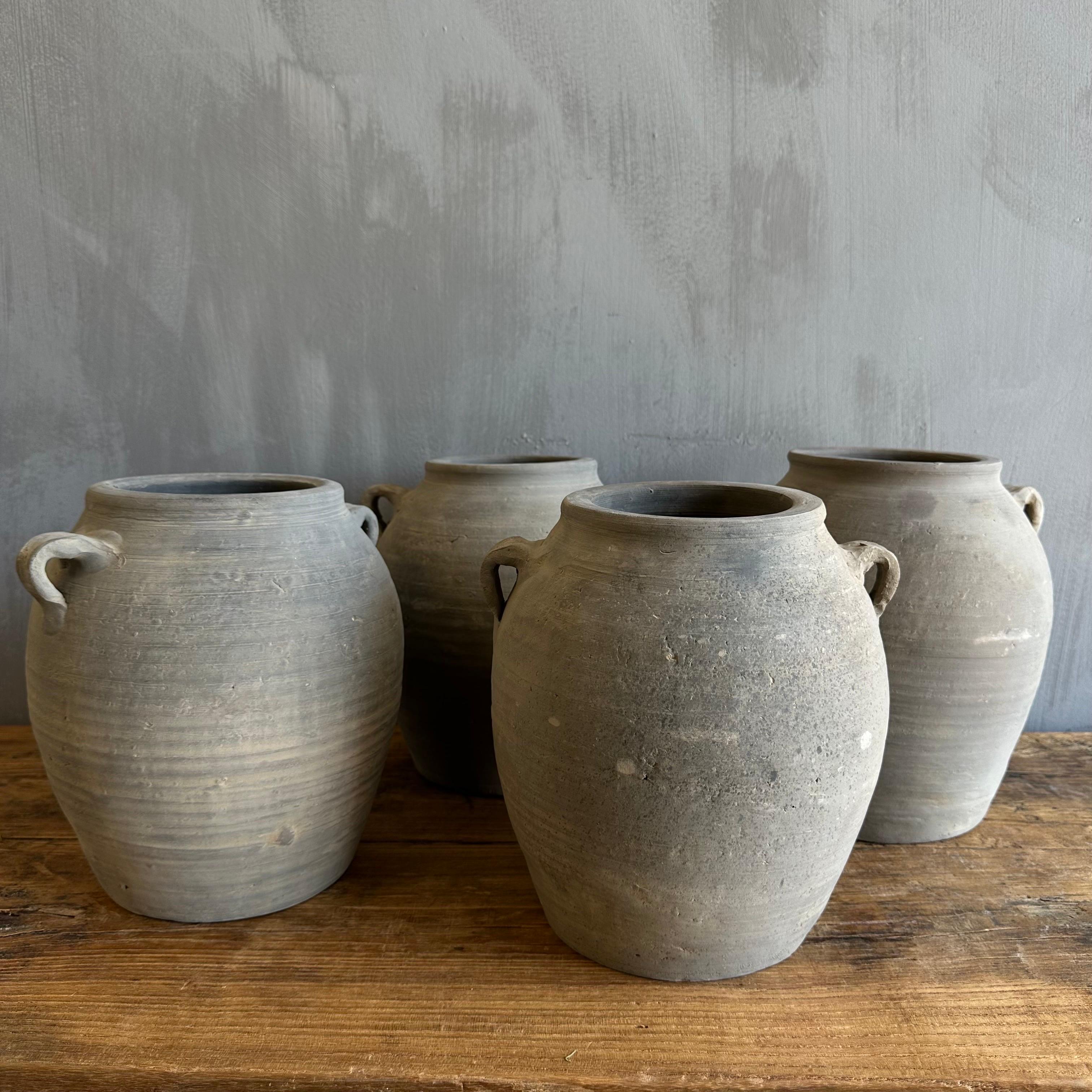 Beautiful weathered grey vintage clay pot that is beautifully colored and authentically worn. 
The surface of the pot and handle are peeling in places, revealing the original clay below. These qualities give the pot a lived-in appearance and will