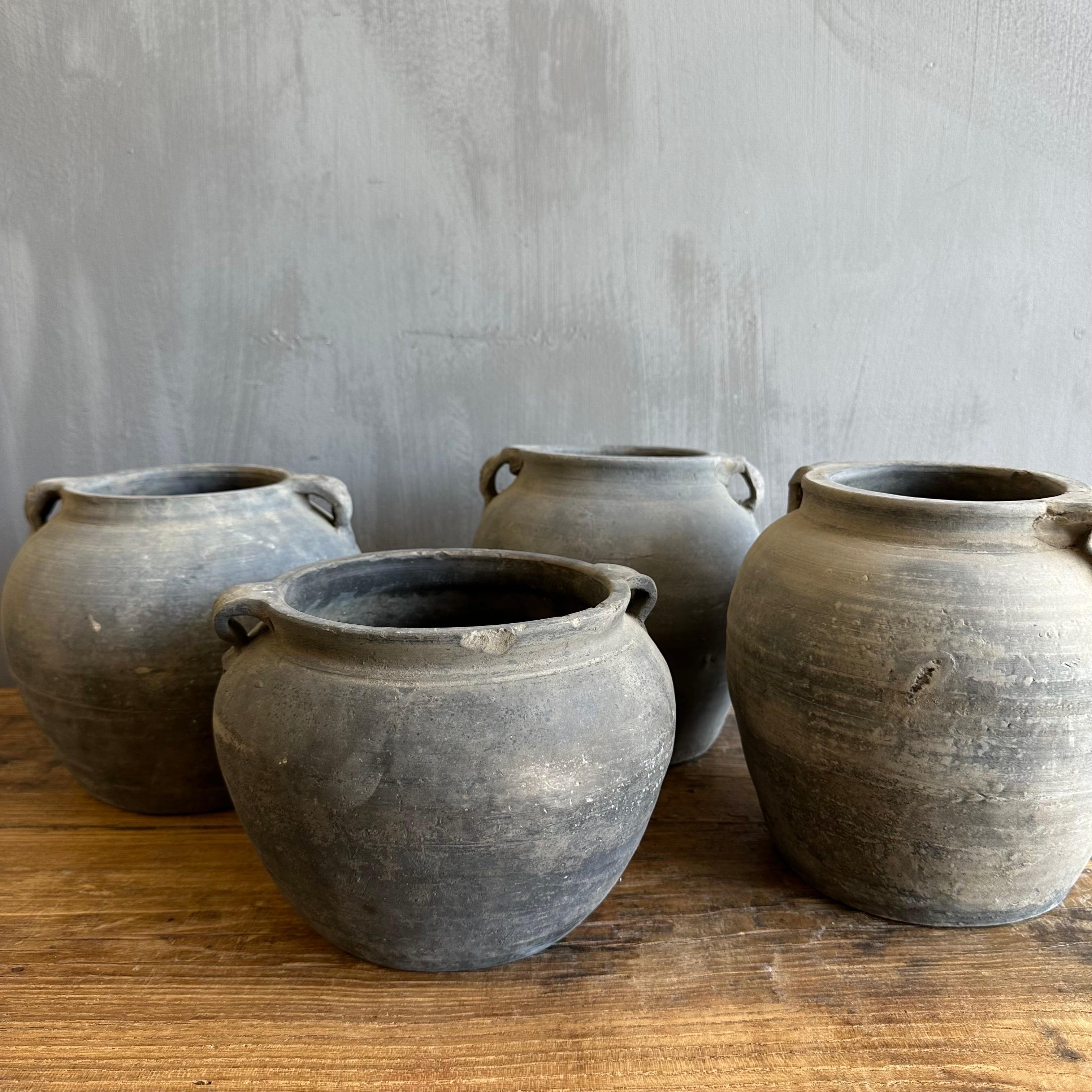 Beautiful weathered grey vintage clay pot that is beautifully colored and authentically worn. The surface of the pot and handle are peeling in places, revealing the original clay below. These qualities give the pot a lived-in appearance and will