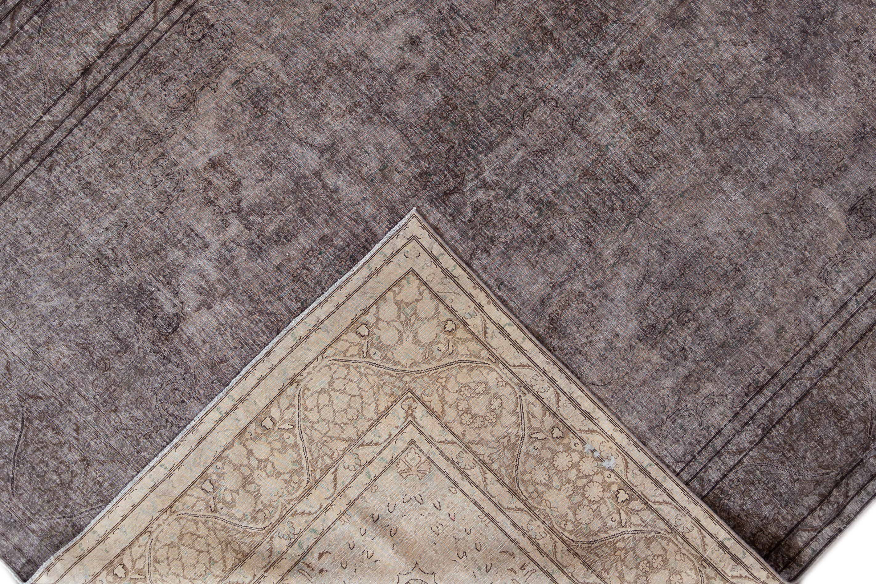 Beautiful vintage overdyed hand knotted wool rug with a gray field. This overdyed rug has brown accents in an all-over distressed floral medallion design.

This rug measures 9' 8